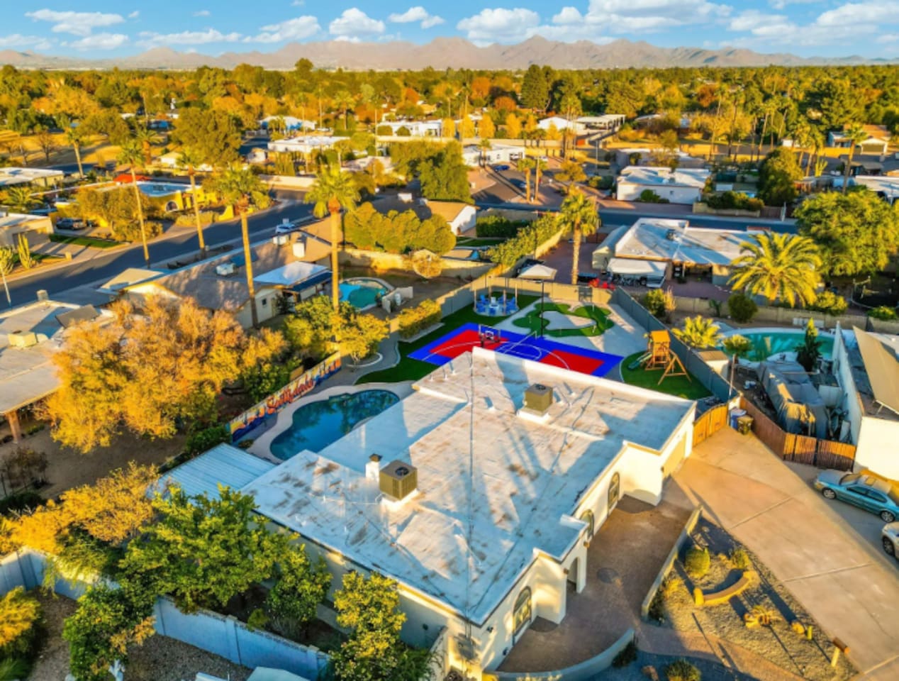 Pool, court, and putting green all visible in one frame — the kind of layout that lets everyone do their own thing at once.