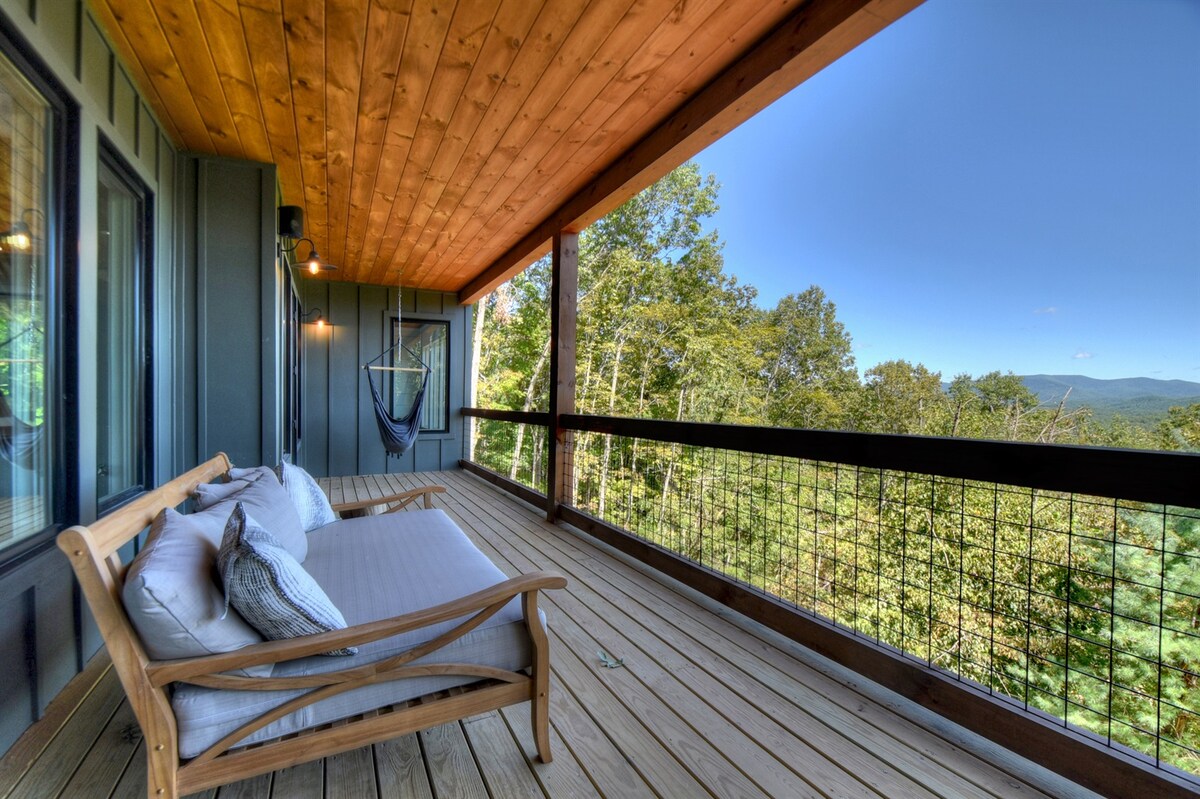 Daybed and hanging chairs overlook the mountains