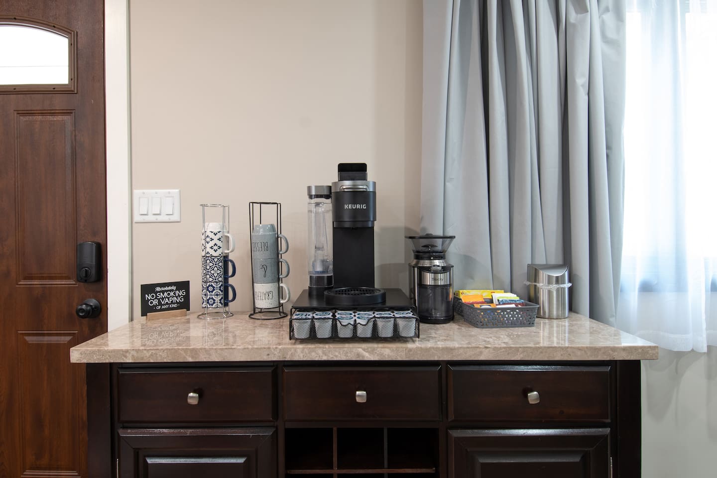 Coffee/tea bar with coffee grinder. Bar has some coffee and tea to get you started until you go grocery shopping. There is also sugar and powdered creamer.