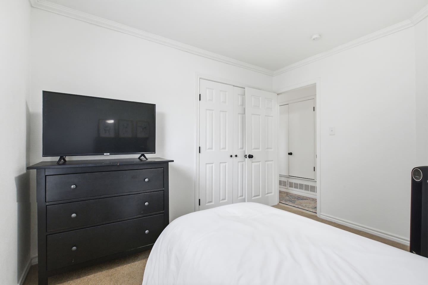 Bedroom with single bed, fresh linens, Smart TV, and room darkening shades for comfortable rest.