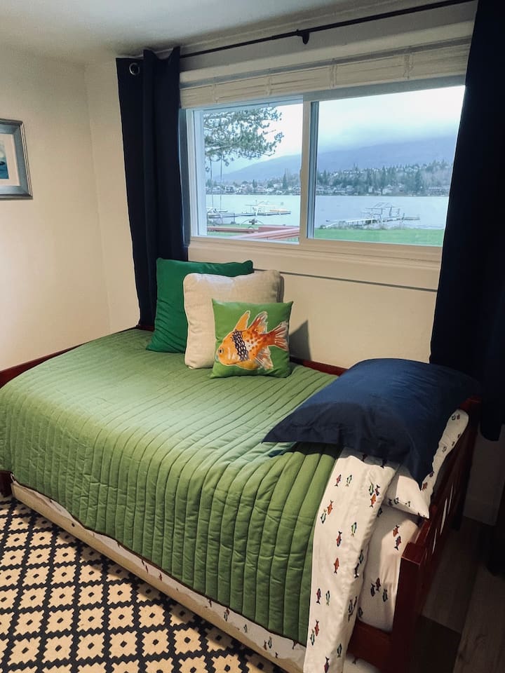 A whimsical space for kids with twin and trundle beds, where ocean creatures and moonlit adventures inspire imagination, all with a peaceful lake view just beyond the window.