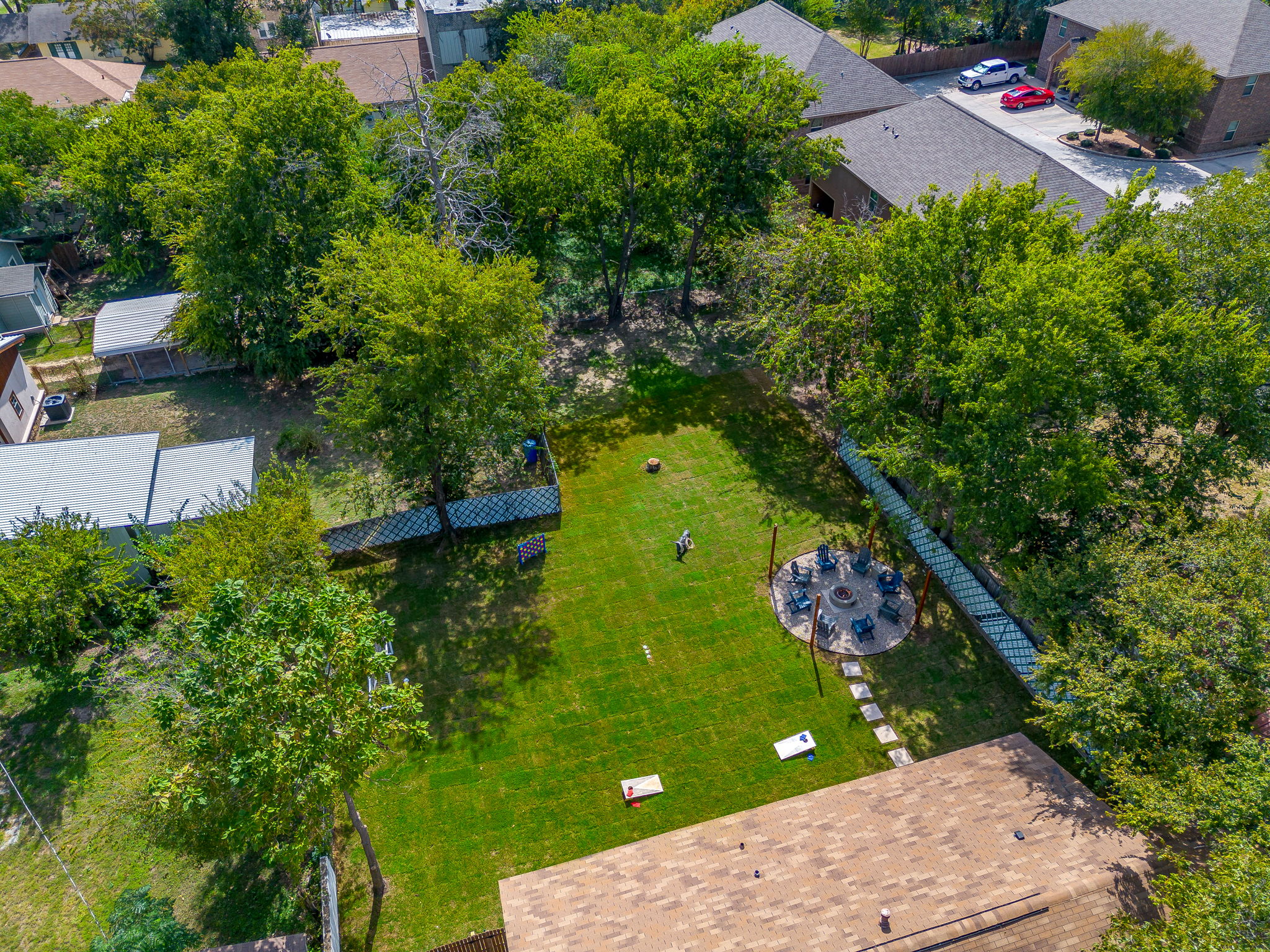 Private green backyard with fire pit and lawn games ready for outdoor fun