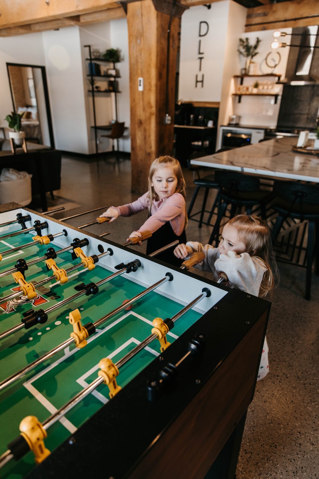 Two kids playing foosball in a Brix condo in Canal Park
