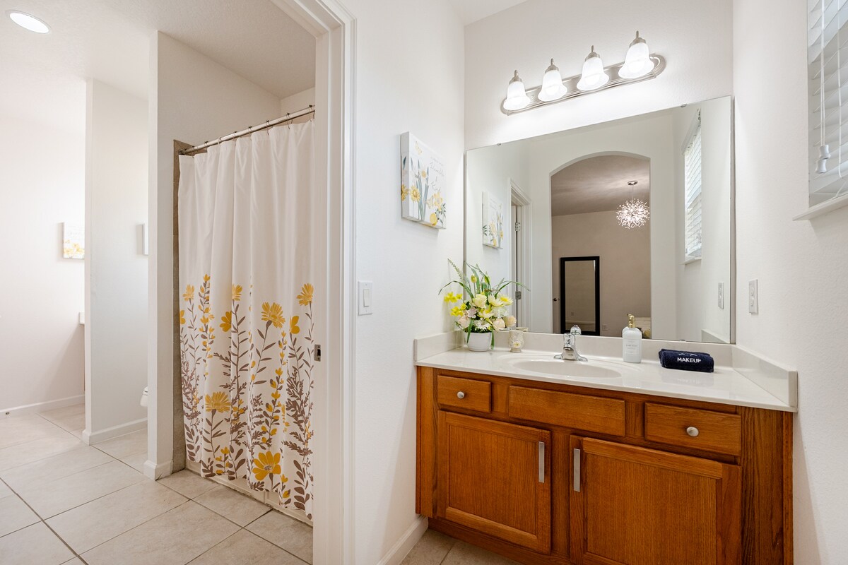Upstairs Sunshine bathroom with a vanity and yellow floral shower curtain.