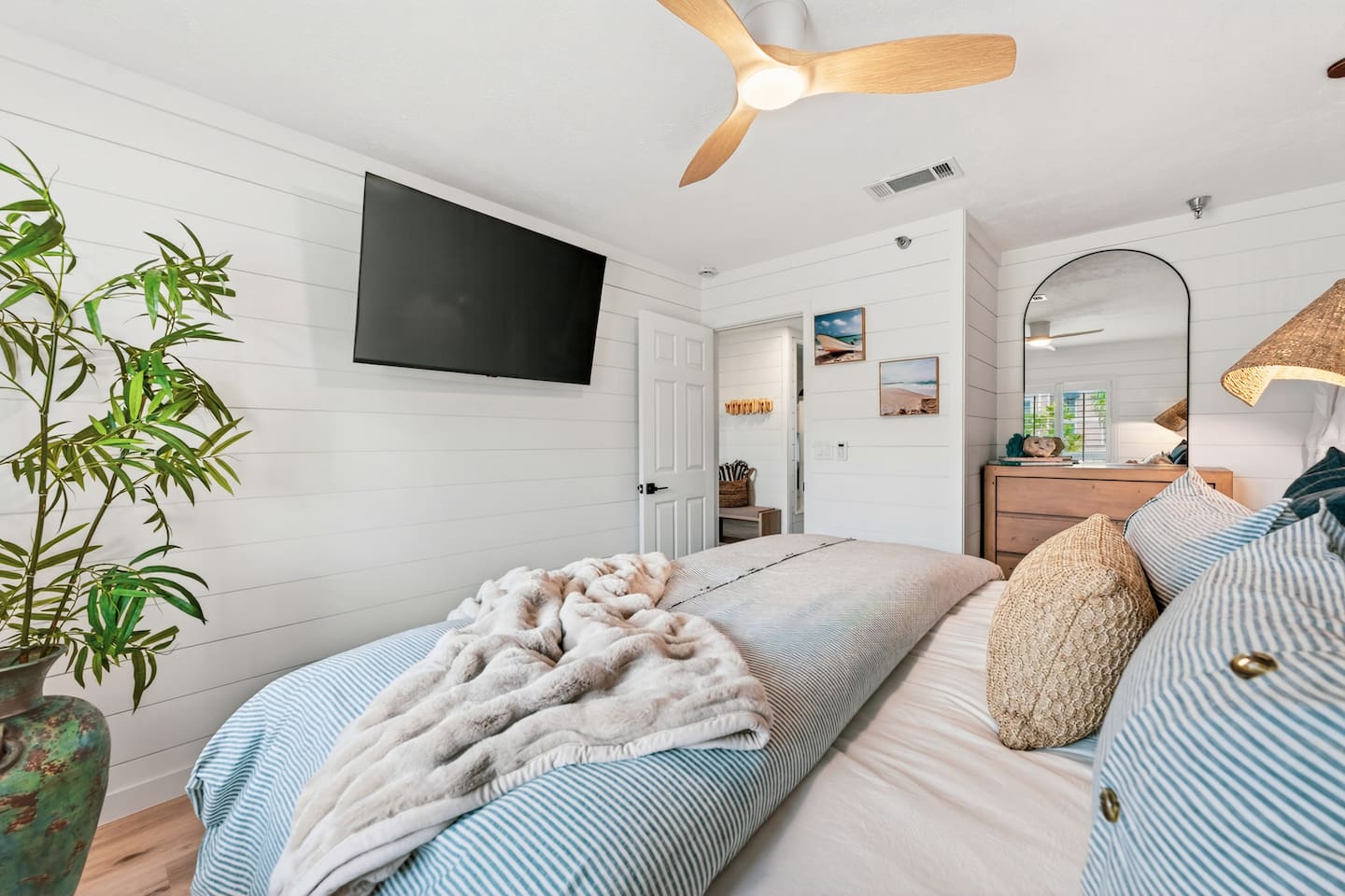 Coastal luxury king suite at El Secreto Azul — hand-crafted wood platform bed, rattan pendant lighting, shiplap walls, and plush bedding designed for the deepest sleep after a perfect day on Destin Beach.