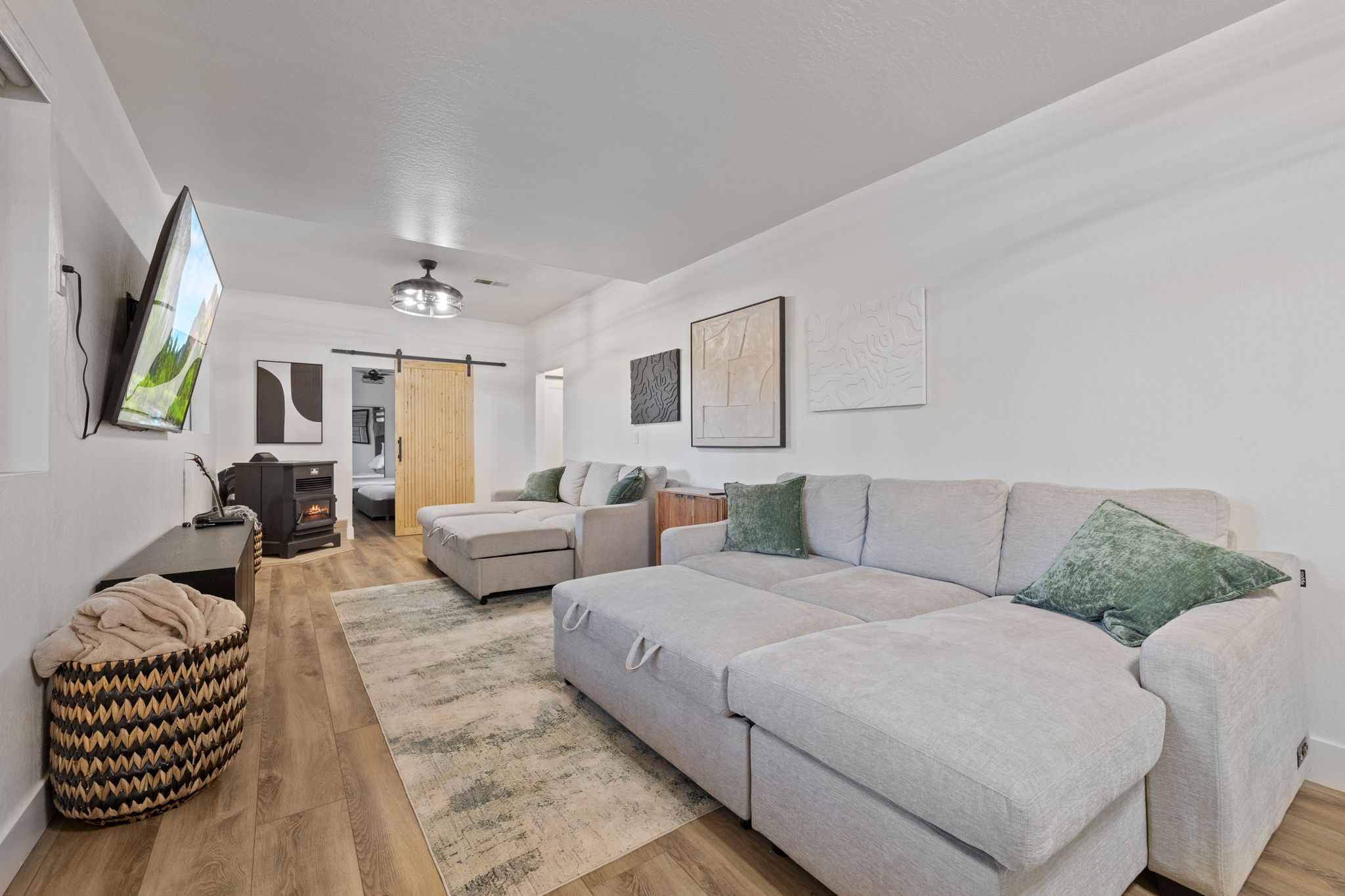 Living room downstairs with 2 pull out sofa beds, big screen tv, pellet stove and kareoke stereo set.