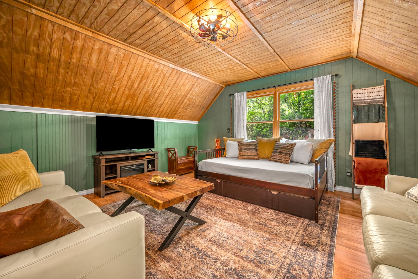 Additional lounge and sleeping space connected to the master suite, featuring a daybed, cozy seating area, and TV. 