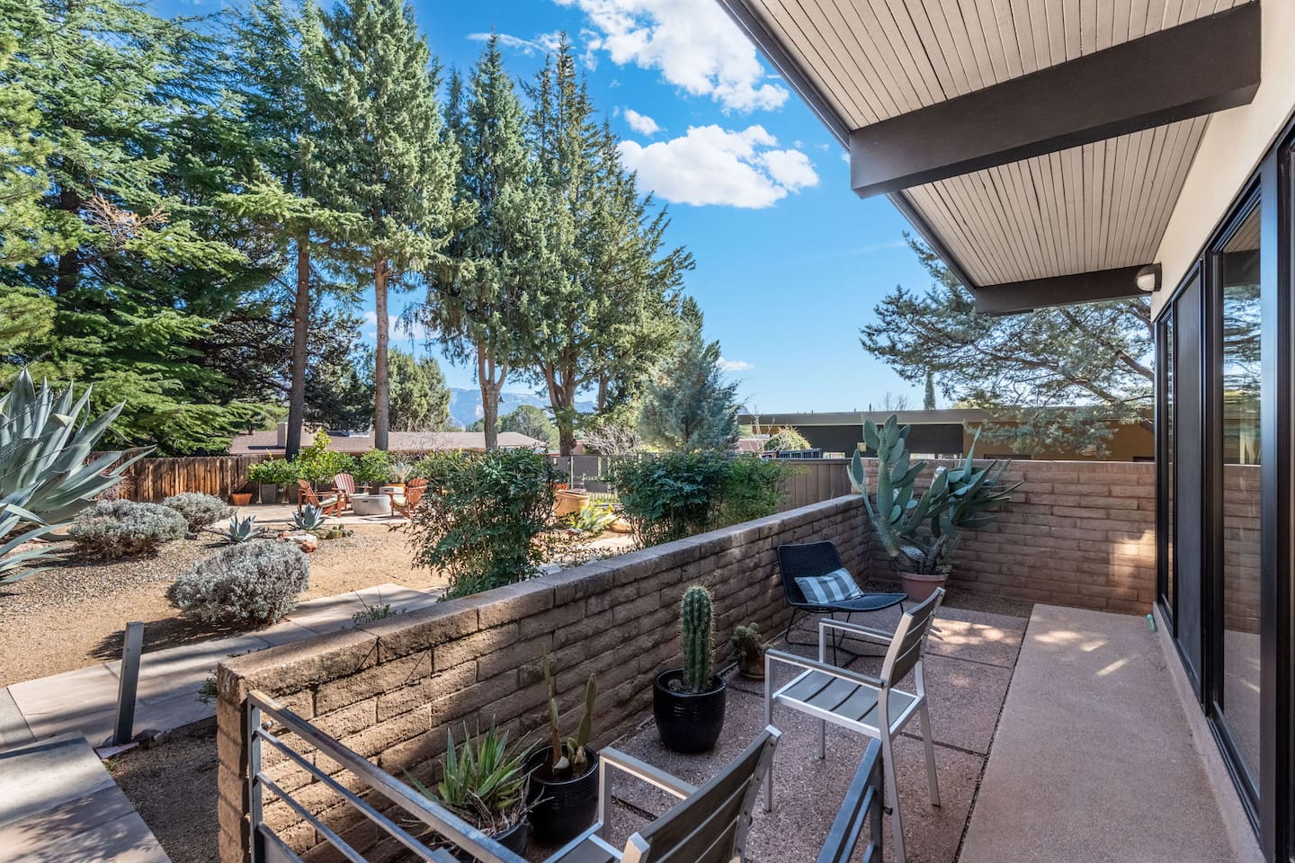 Peaceful side patio overlooking desert landscaping, complete with seating and native plants.