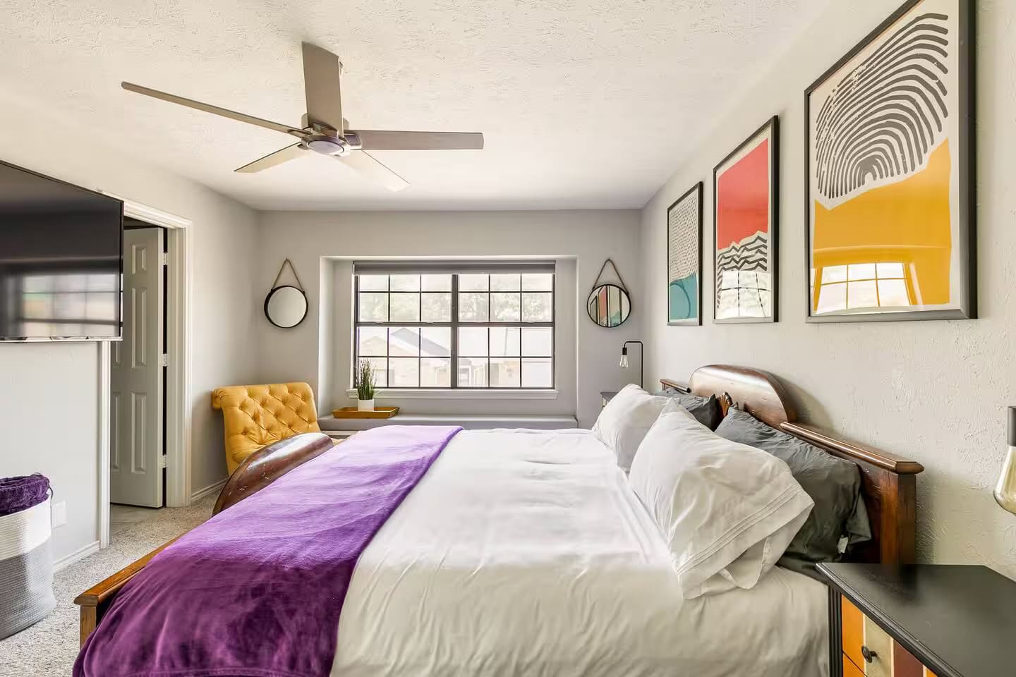 Spacious bedroom with king bed and vibrant wall art.
