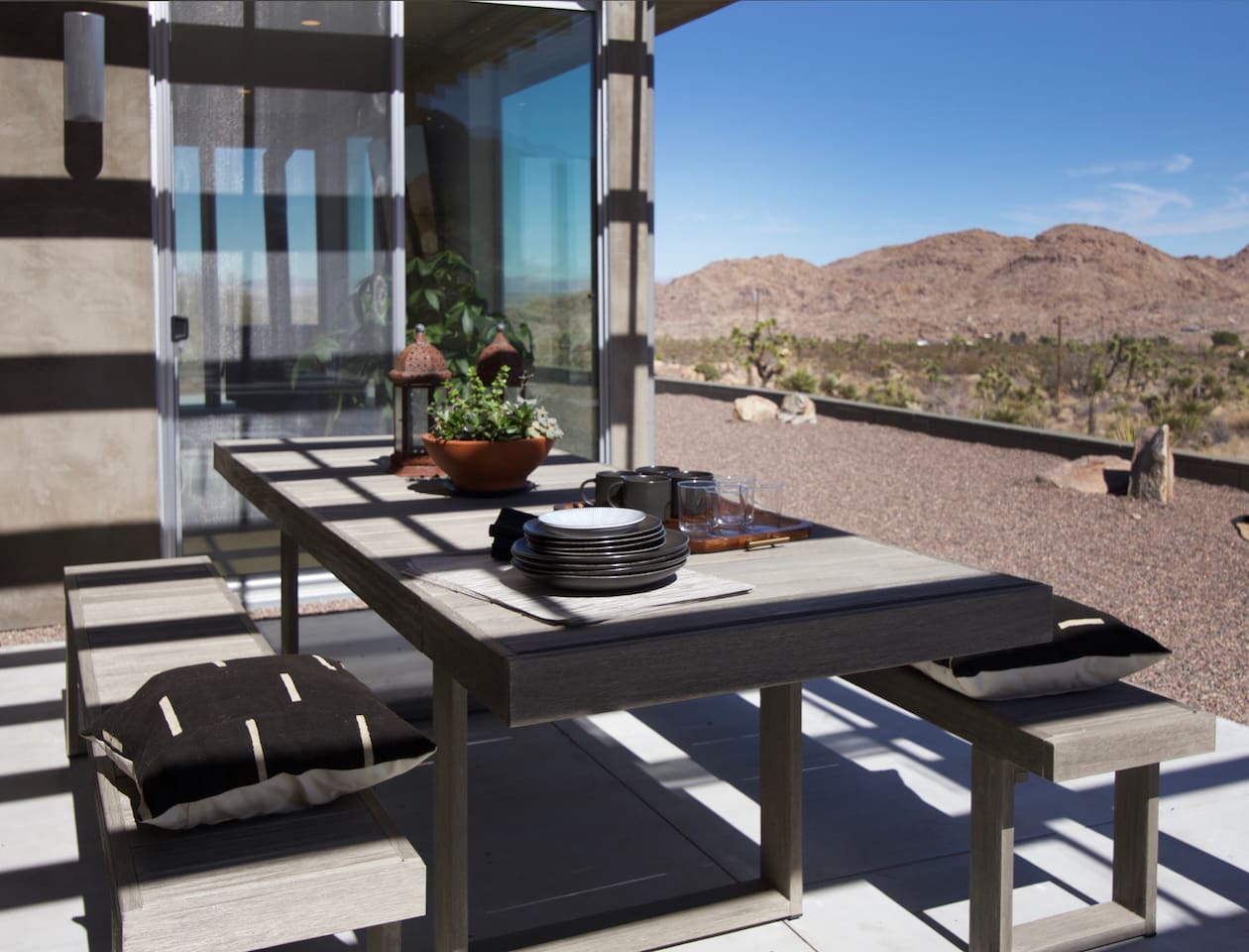 Enjoy meals at the outdoor dining table while taking in sweeping Joshua Tree desert and mountain views.