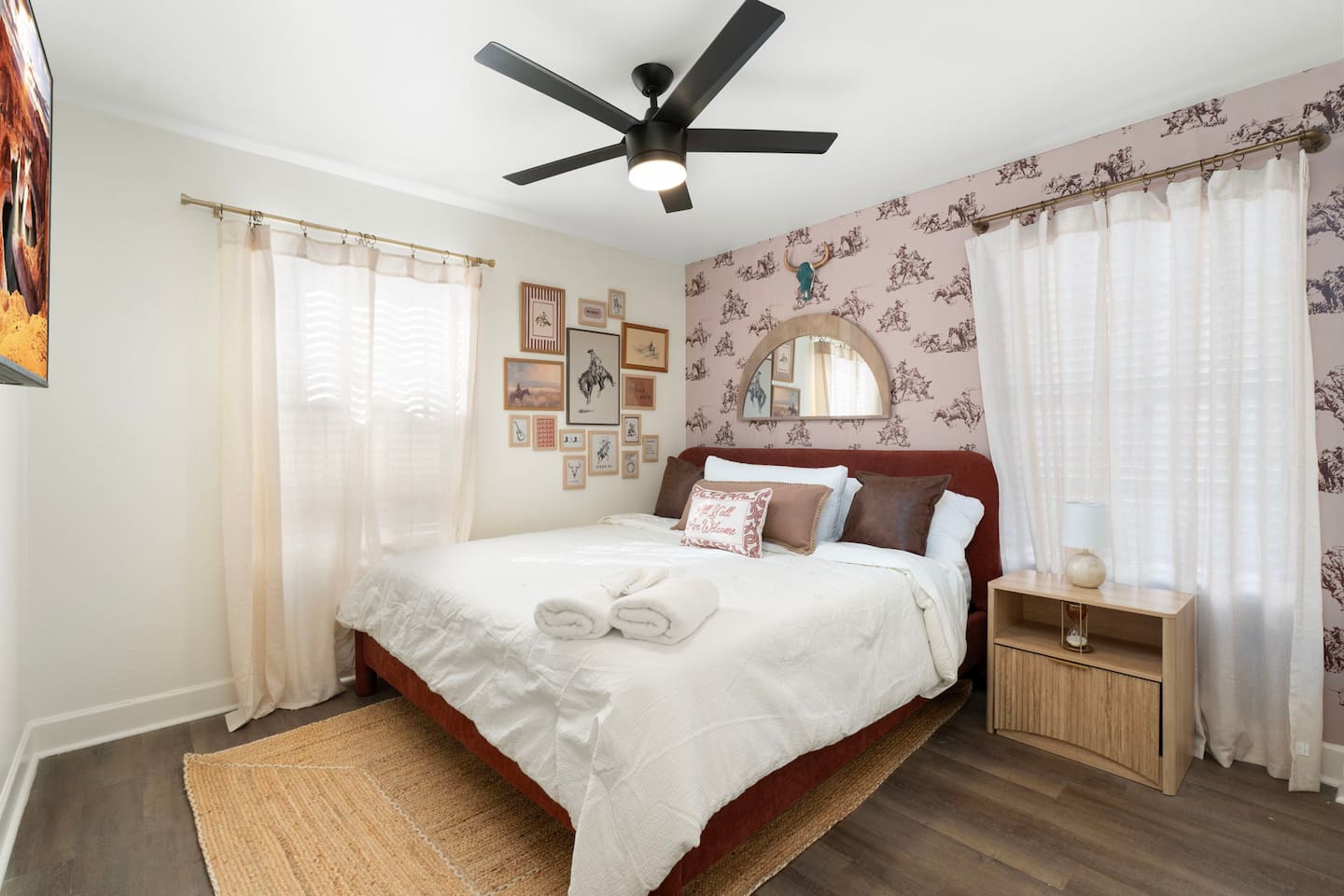 Cozy guest bedroom with burgundy headboard, patterned wallpaper, and natural light—intimate and inviting with vintage charm.