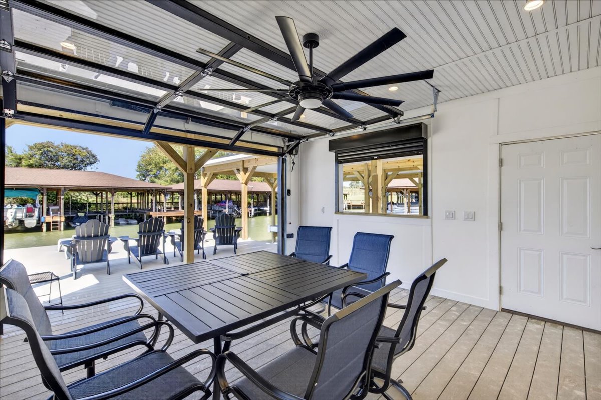 Finished boathouse entertaining area with dining space and a full-view glass garage door.