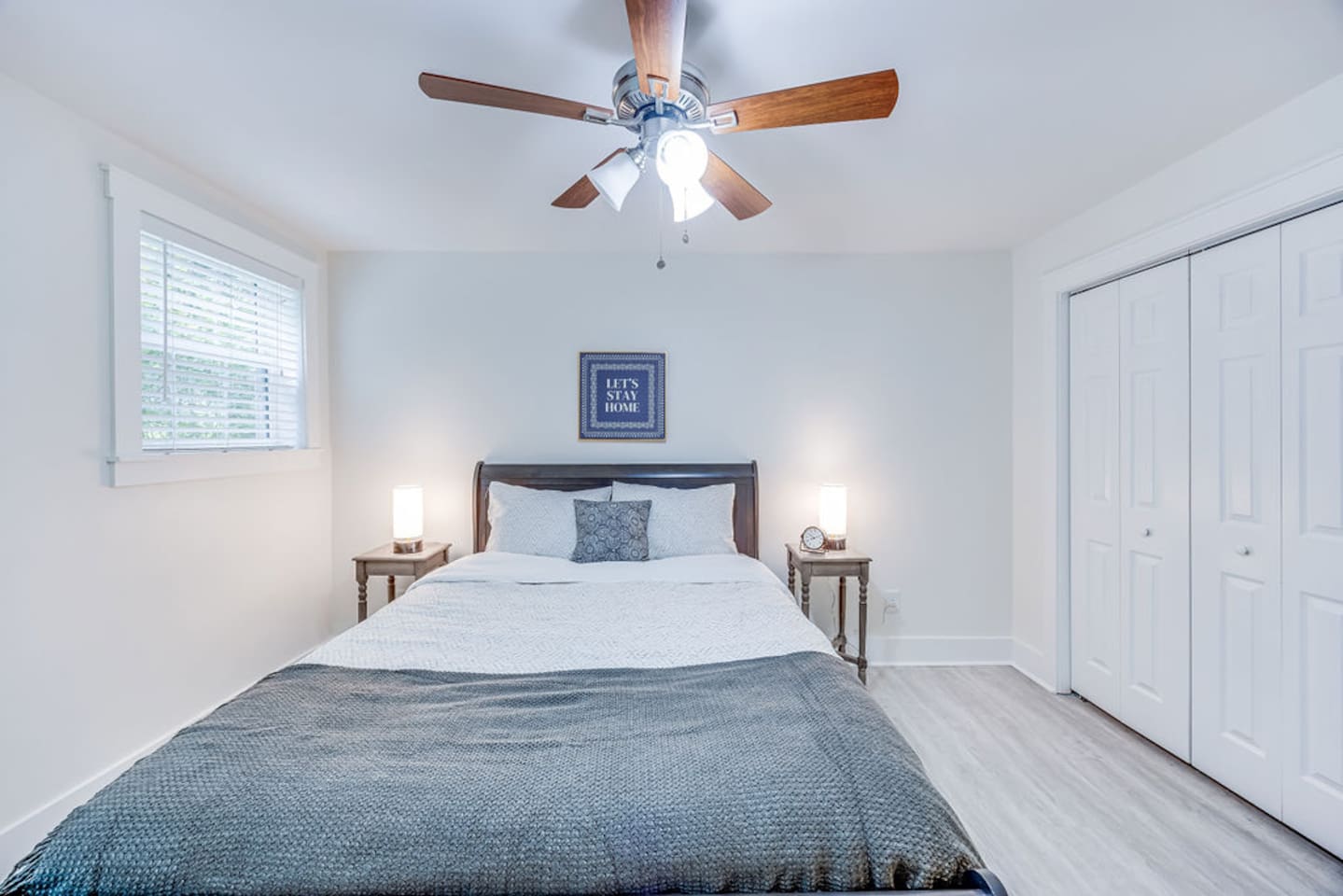Comfortable bed complemented by a stylish ceiling fan and a charming little window, offering a cool, breezy atmosphere for a restful stay.