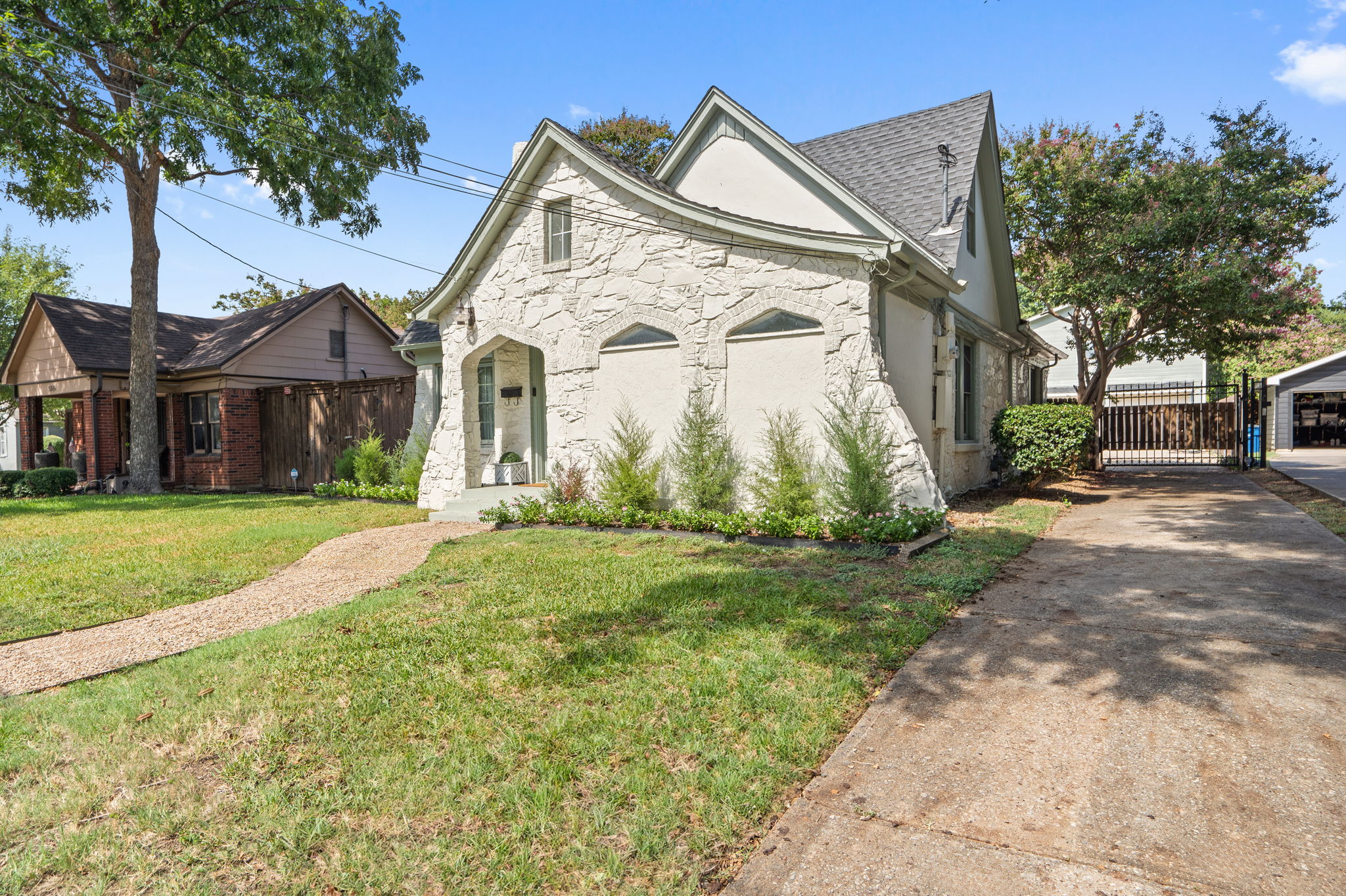 Full front view of the 1929 stone exterior and driveway. Northwest Dallas location puts guests minutes from Love Field Airport, the Medical District, Dallas Market Center, the Design District, and Uptown dining and nightlife.