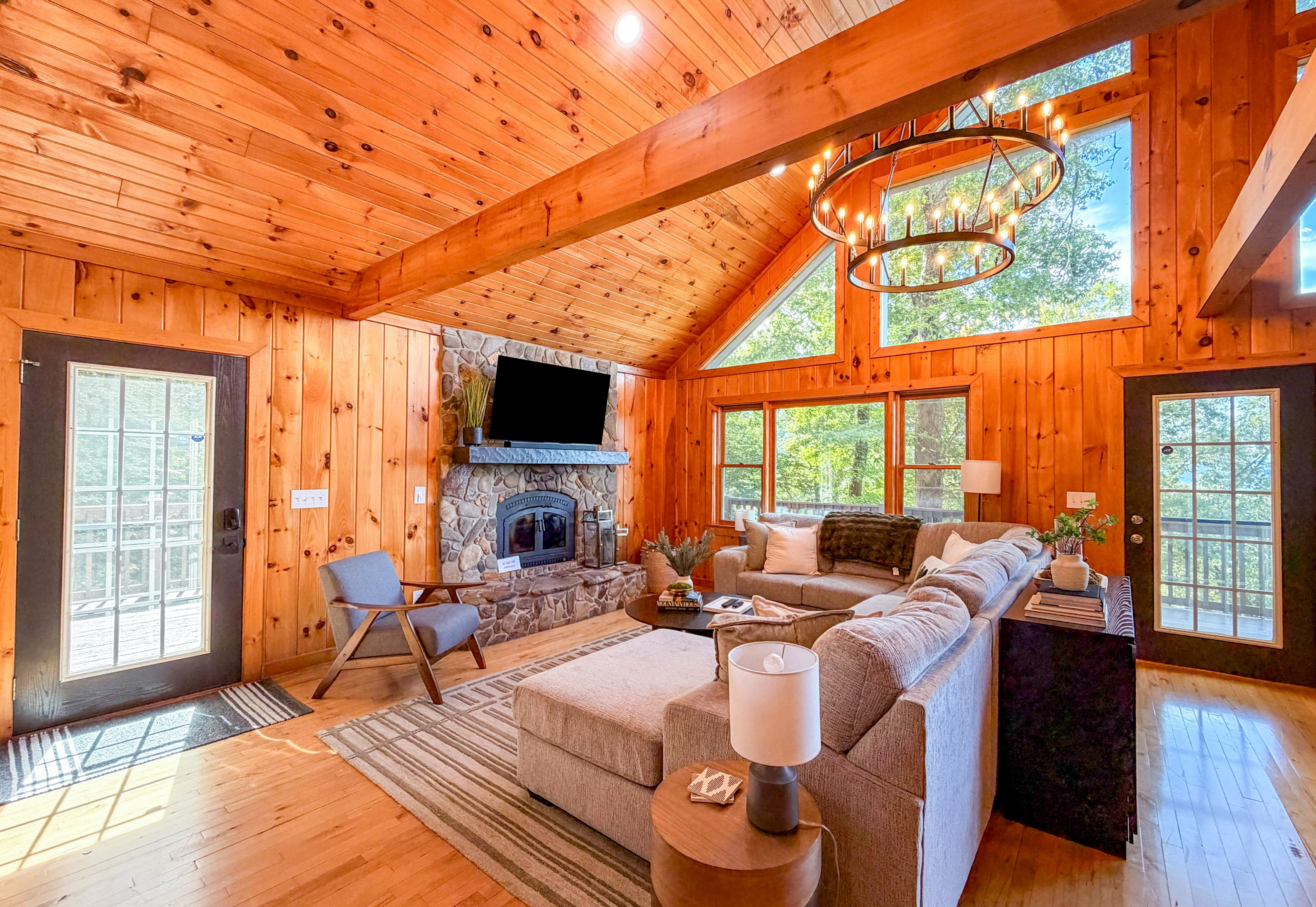 Step into our serene living room, where lush green foliage frames every window(please note there is no fireplace listed as an amenity).
