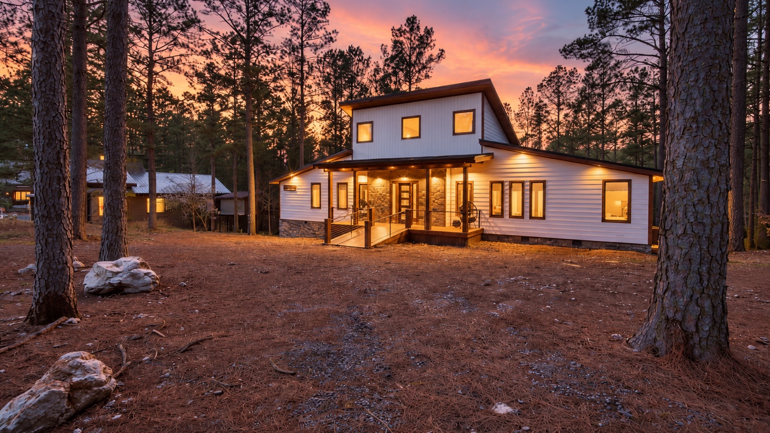 Come home to glowing windows and a sunset painted through the pines.