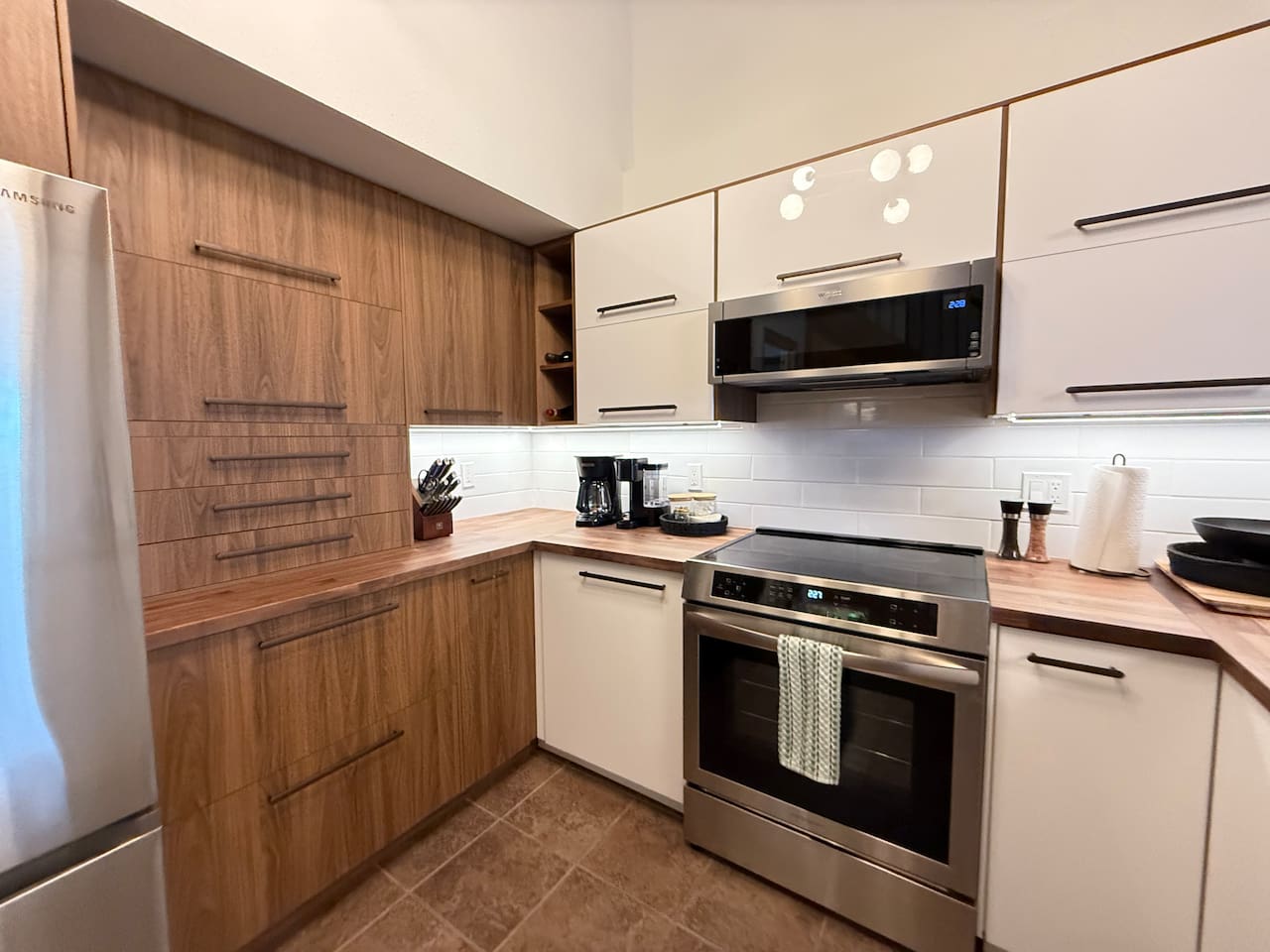 Modern Cooking Appliances: The kitchen boasts a sleek induction stove and range, a built-in dishwasher, and wood accents, making meal prep a breeze during your mountain getaway.