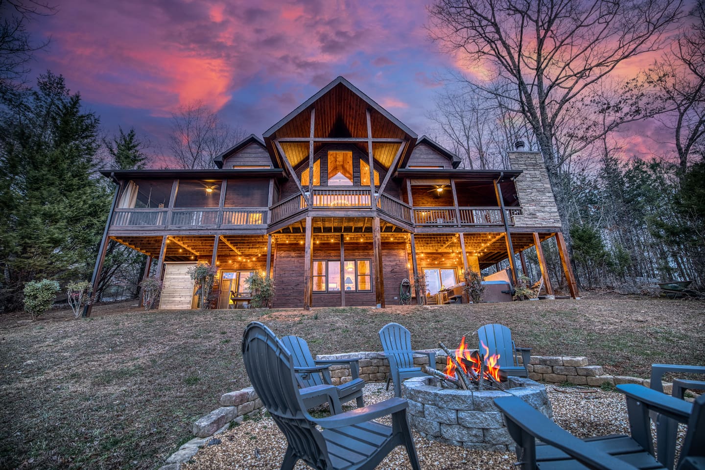 Fire pit in the back of the beautiful "Blessed Sunset" mountain retreat home overlooking the back yard! Stunning A-frame, wrap-around porch, screened-in patio, outdoor fireplace, outdoor dining table, sauna, hot tub, outdoor couch, and more!