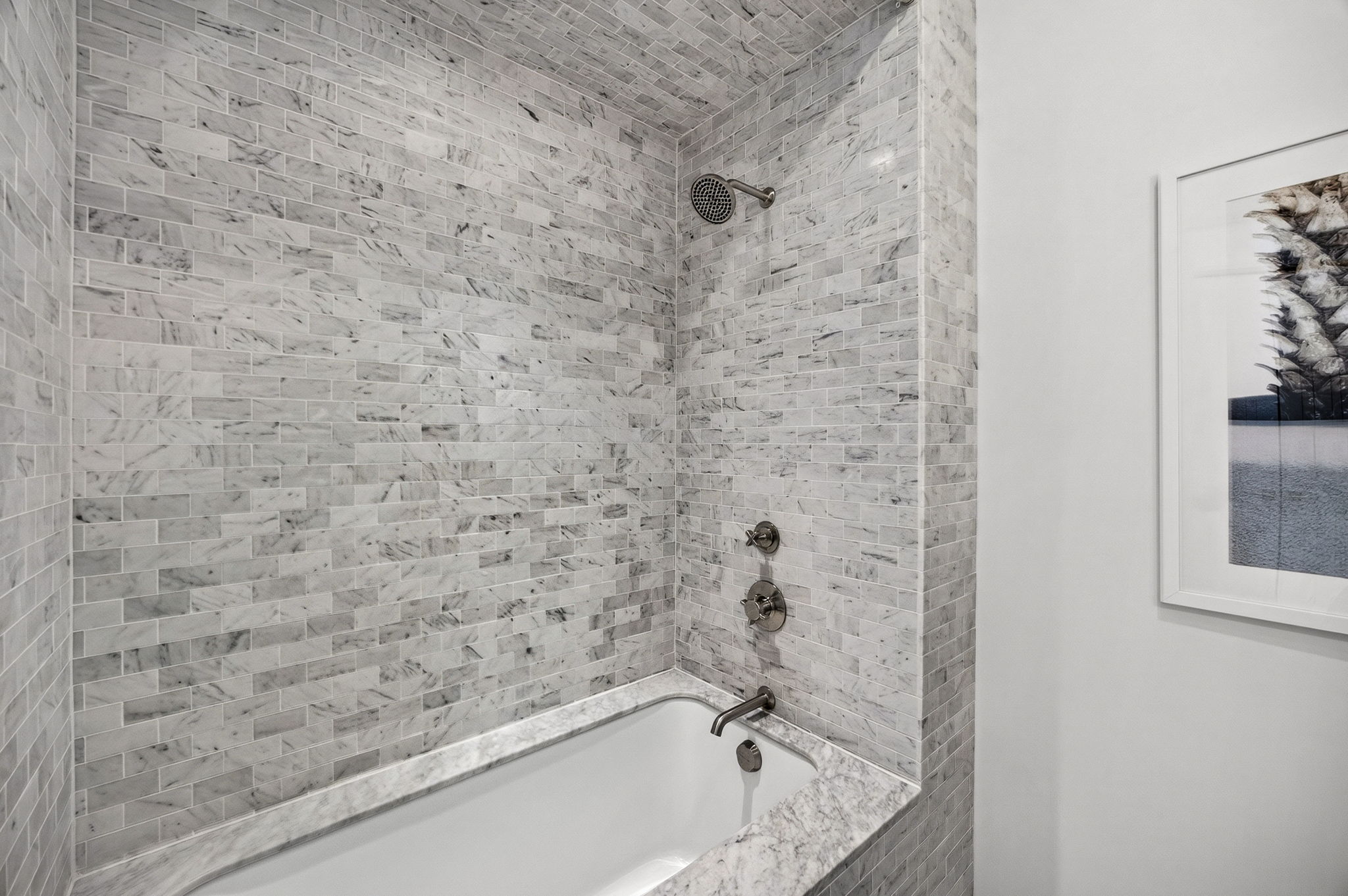 Guest Suite #1 Ensuite bath offers a deep soaking tub with marble surround.
