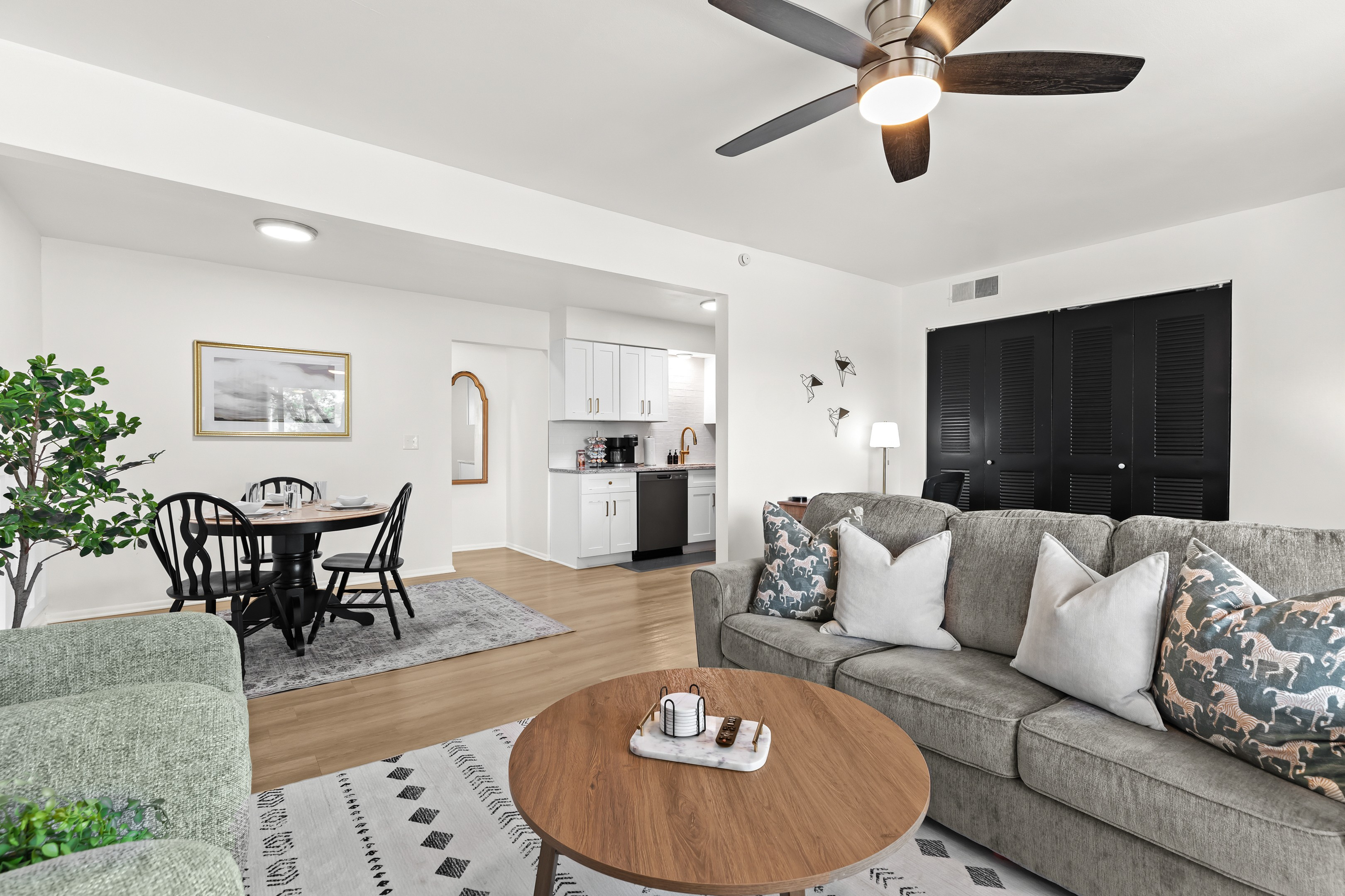 Bright and open living space with ceiling fan, stylish decor, and seamless flow into the dining area.