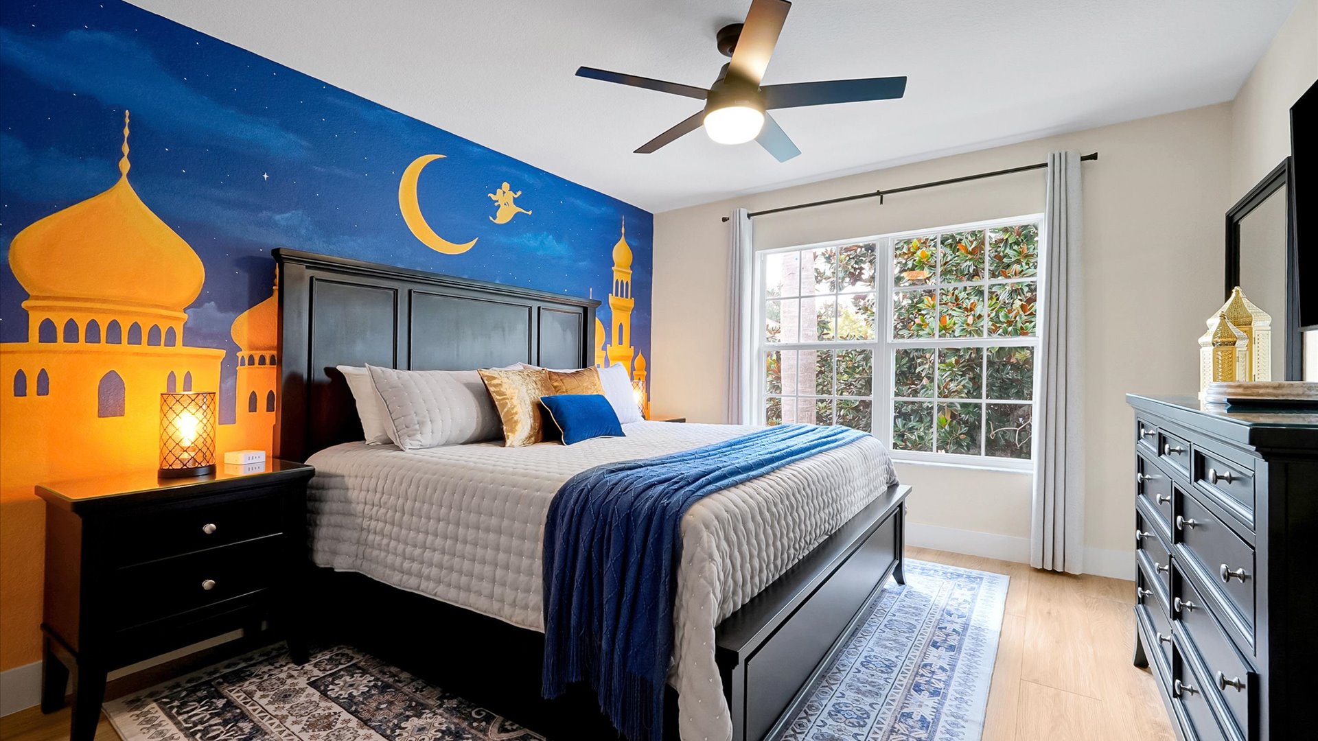 Aladdin King Suite: King-size bed framed by a dramatic palace mural and warm lantern-inspired lighting.