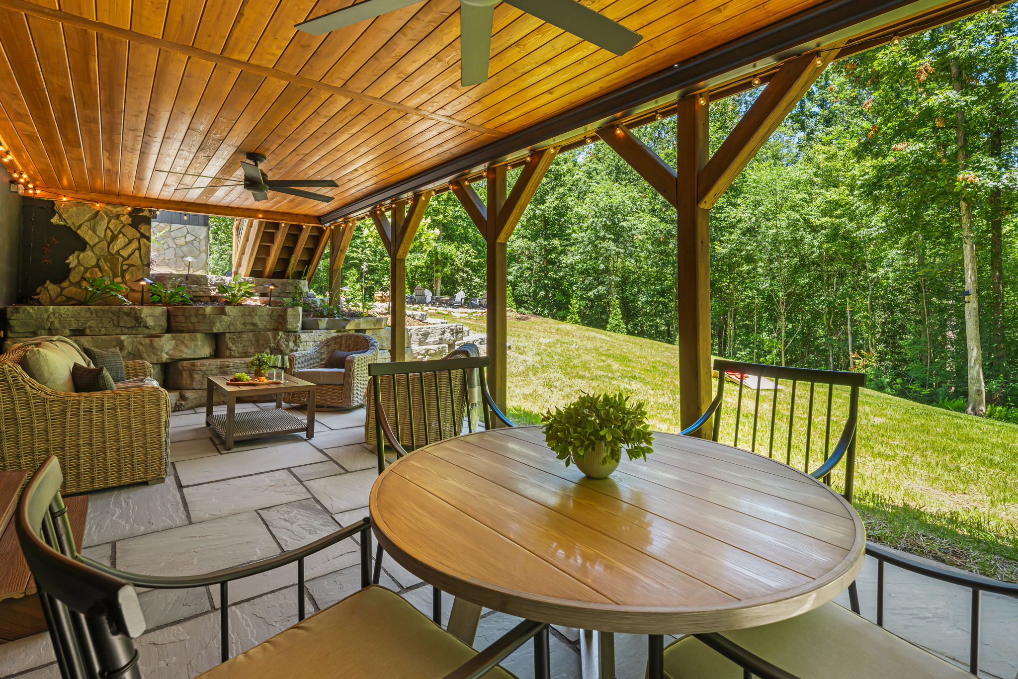 A view of the backyard from the patio setting with a dining table for alfresco dining or to play games and casual comfortable seating.