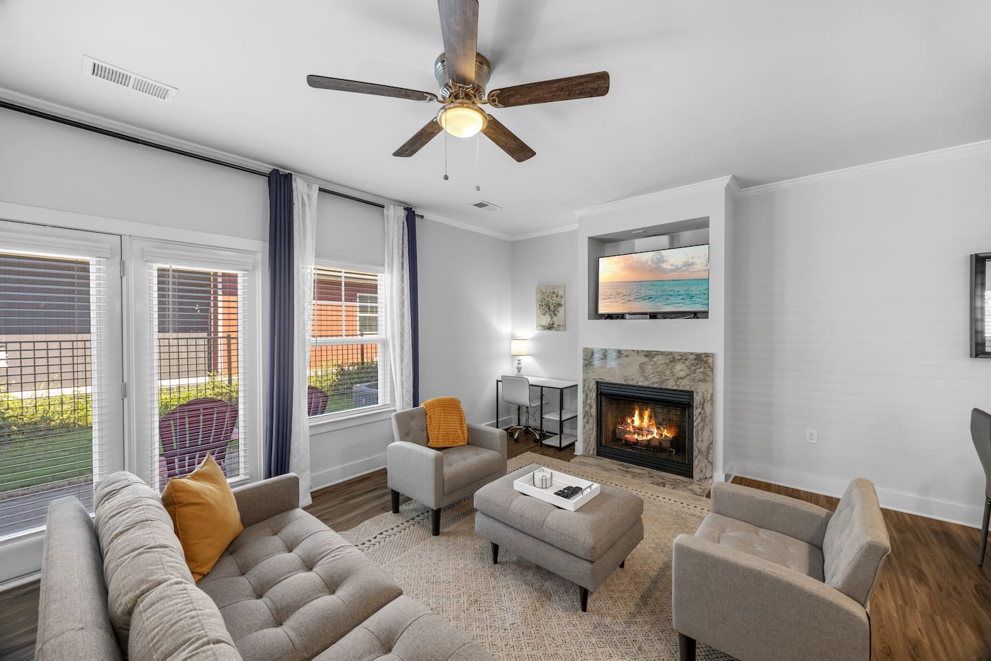 Relax in a stylish space with plush seating, natural light, and a warm fireplace for cozy evenings.