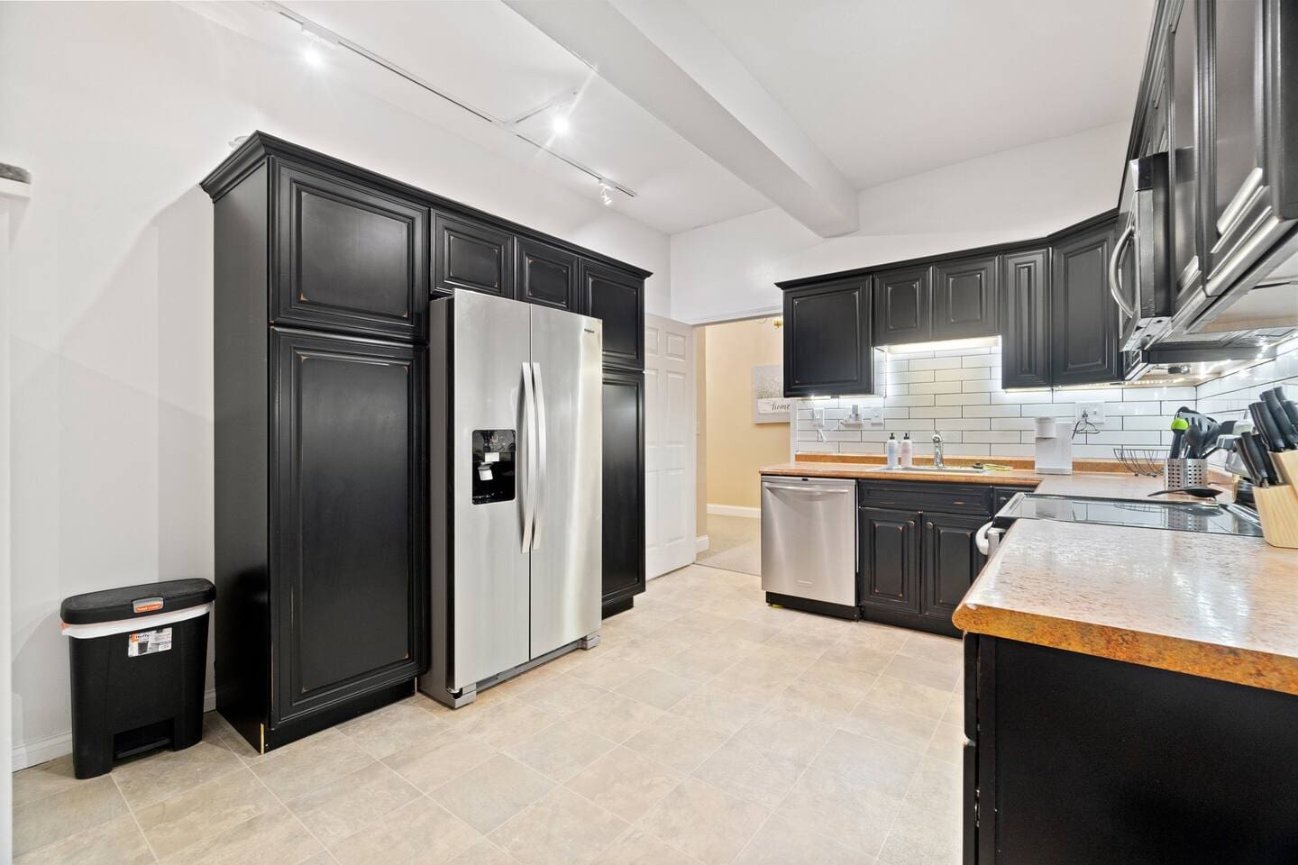 Spacious kitchen featuring a large refrigerator seamlessly integrated with stylish kitchen cabinets for a sleek and functional design.