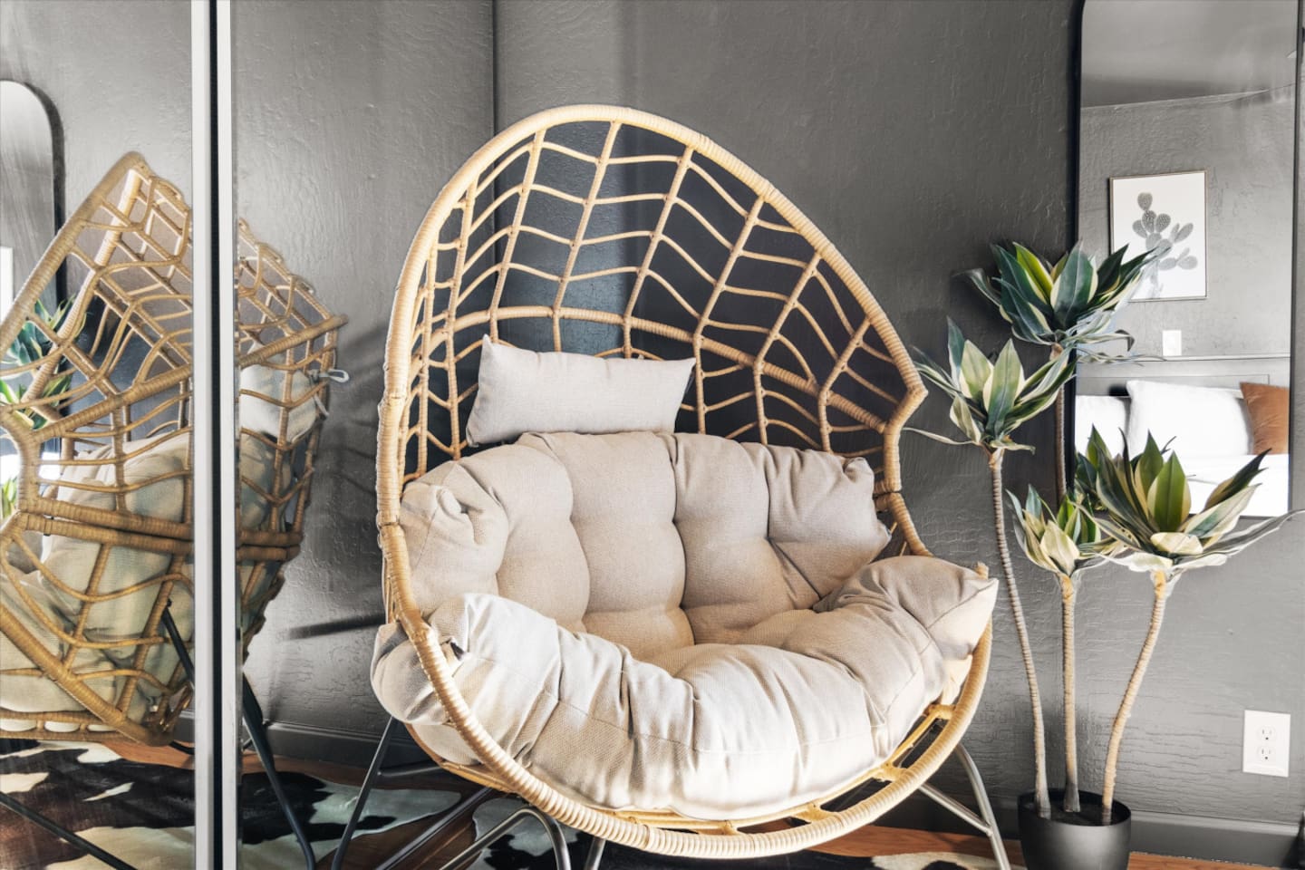 Bedroom sitting corner with a cushioned accent chair, mirror, and a quiet spot to read or unwind.