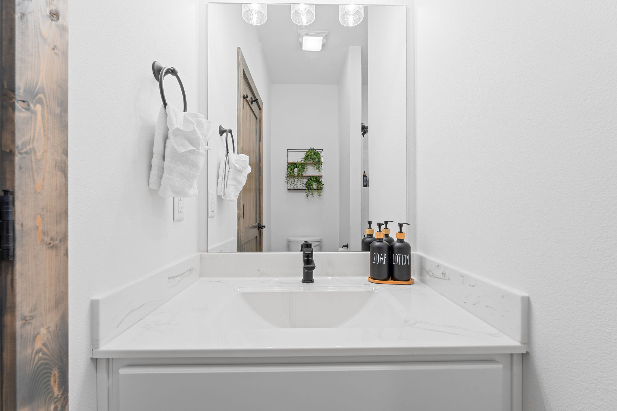 Attached ensuite bright bathroom vanity stocked with essential amenities.