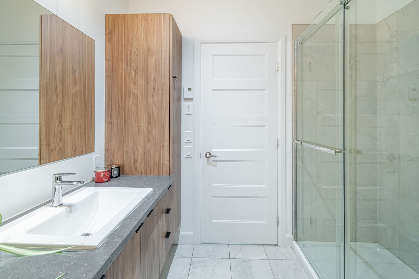 Salle de bain moderne et complète avec douche.