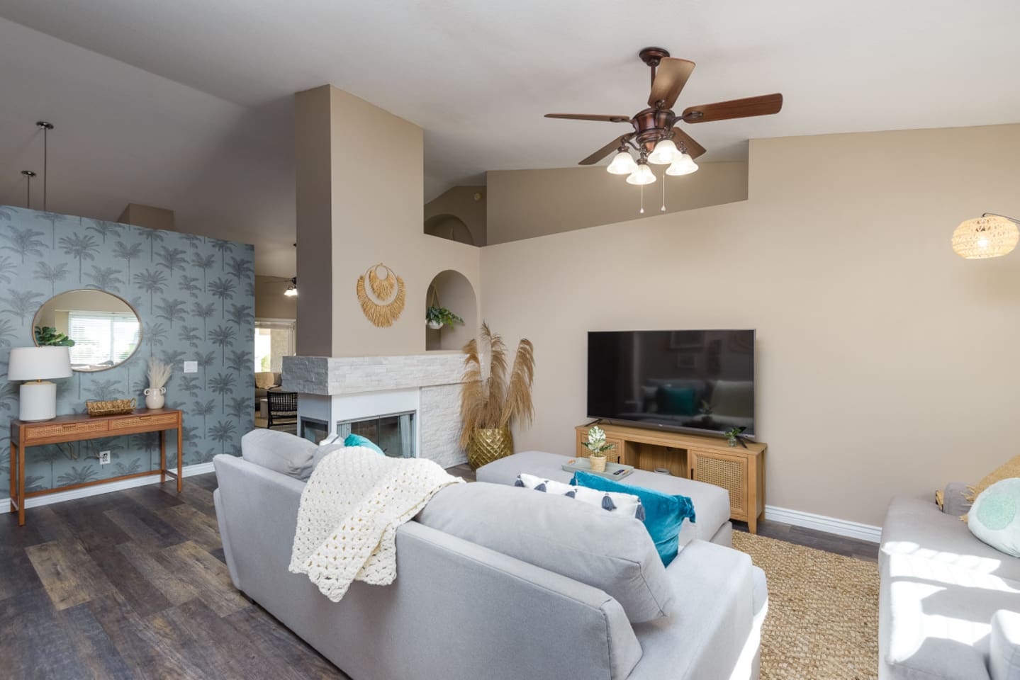 Living room with vaulted ceiling, large Smart TV, comfortable sectional seating, and room to relax or gather indoors.