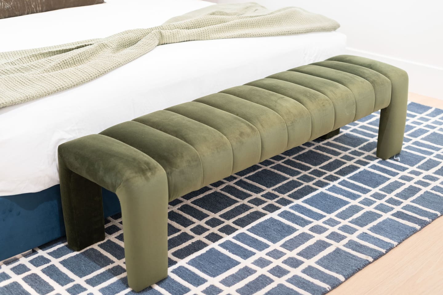 Velvet bench at the foot of the bed adds both style and function.