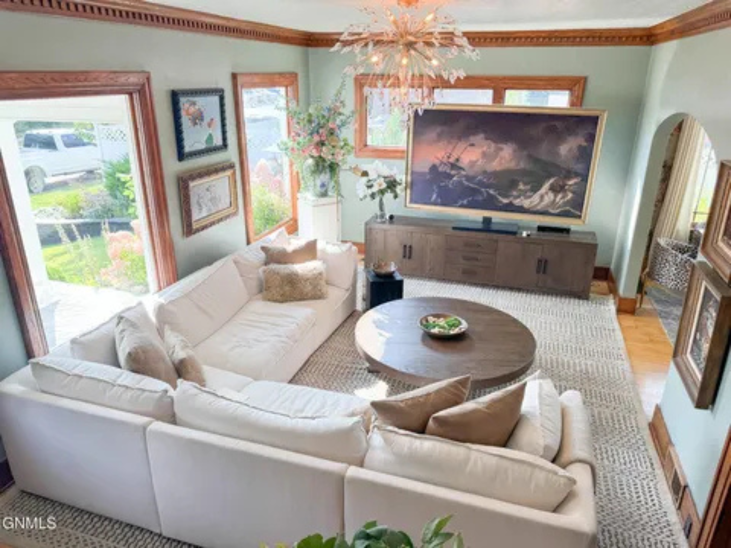 A spacious living room with soft natural light, a large TV, and room for everyone to settle in.