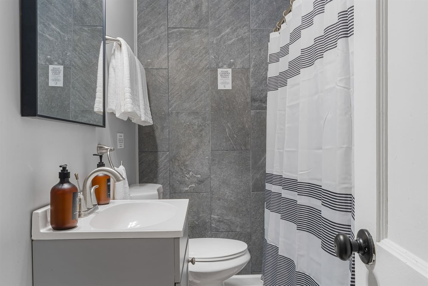 Compact and modern full bathroom with a clean walk-in shower, fresh towels, and complimentary toiletries