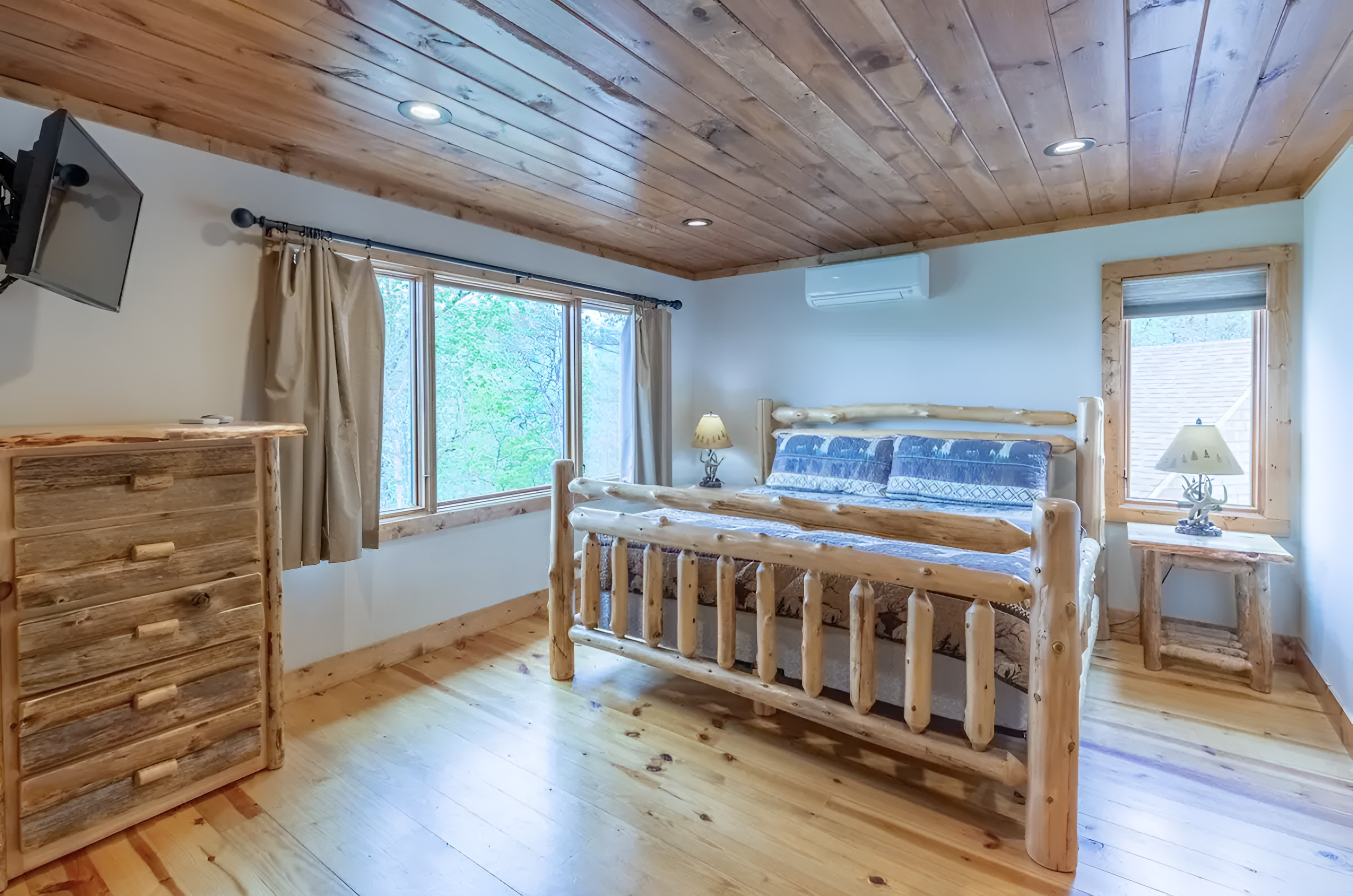 The upper level king bedroom features a cozy setup and a TV.