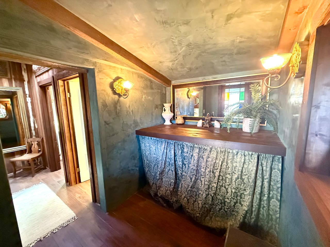 Just inside the courtyard entrance, the design gives guests direct access to both powder rooms without crossing the house. Hand-troweled plaster walls add old-world texture, while the washer and dryer hide neatly behind that tailored curtain.