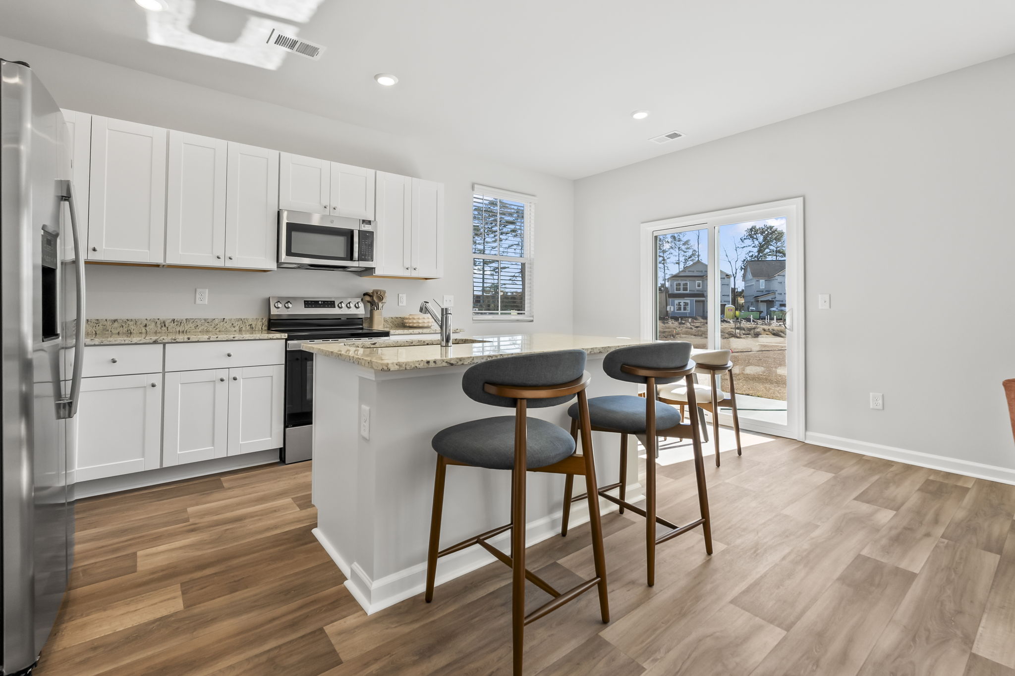 Kitchen with granite countertops and dining table seating 6
