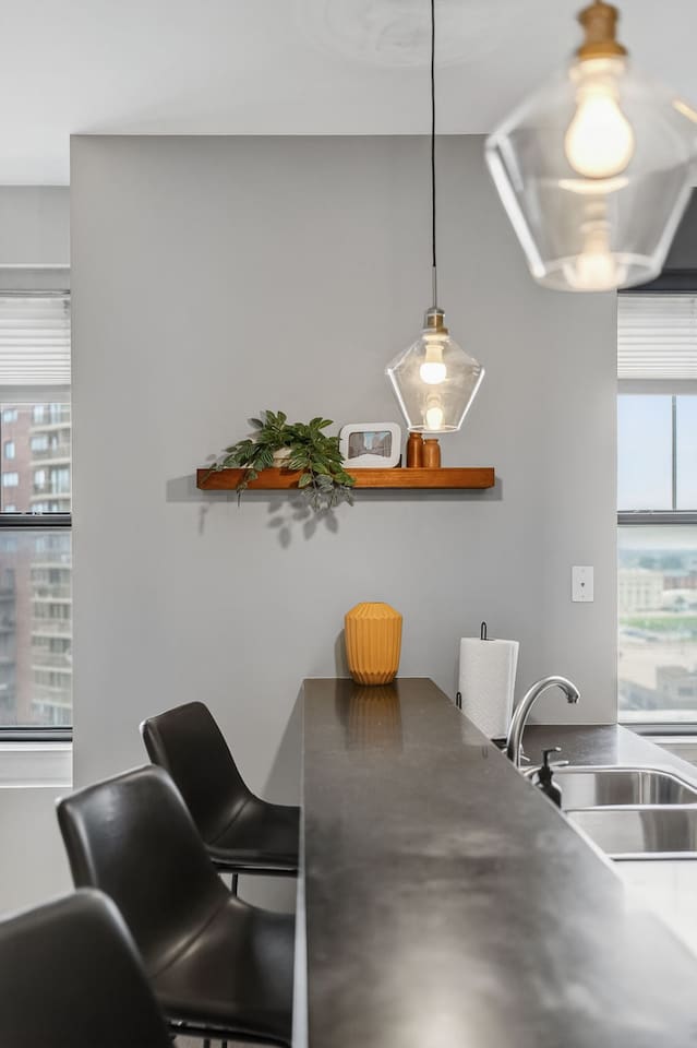 This modern kitchen offers a spacious bar, floating shelf décor, and plenty of counter space. Whether you’re preparing dinner or grabbing takeout, enjoy the perfect blend of style, convenience, and functionality downtown.