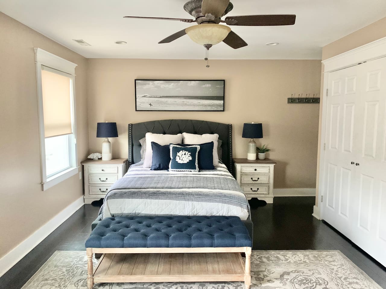 Relax in this bright, modern bedroom featuring a comfortable bed, stylish tufted bench, and coastal decor. This well-appointed area includes ample storage and calming tones, making it easy to enjoy a restful night before heading to the beach.