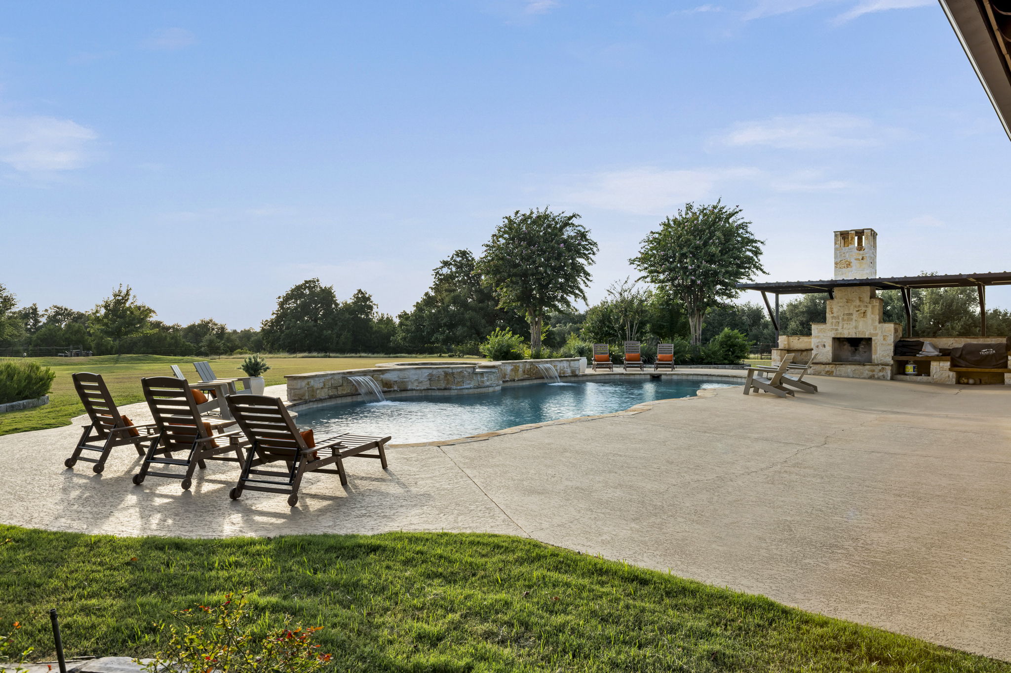 Lounge chairs line the edge of a resort-style pool.