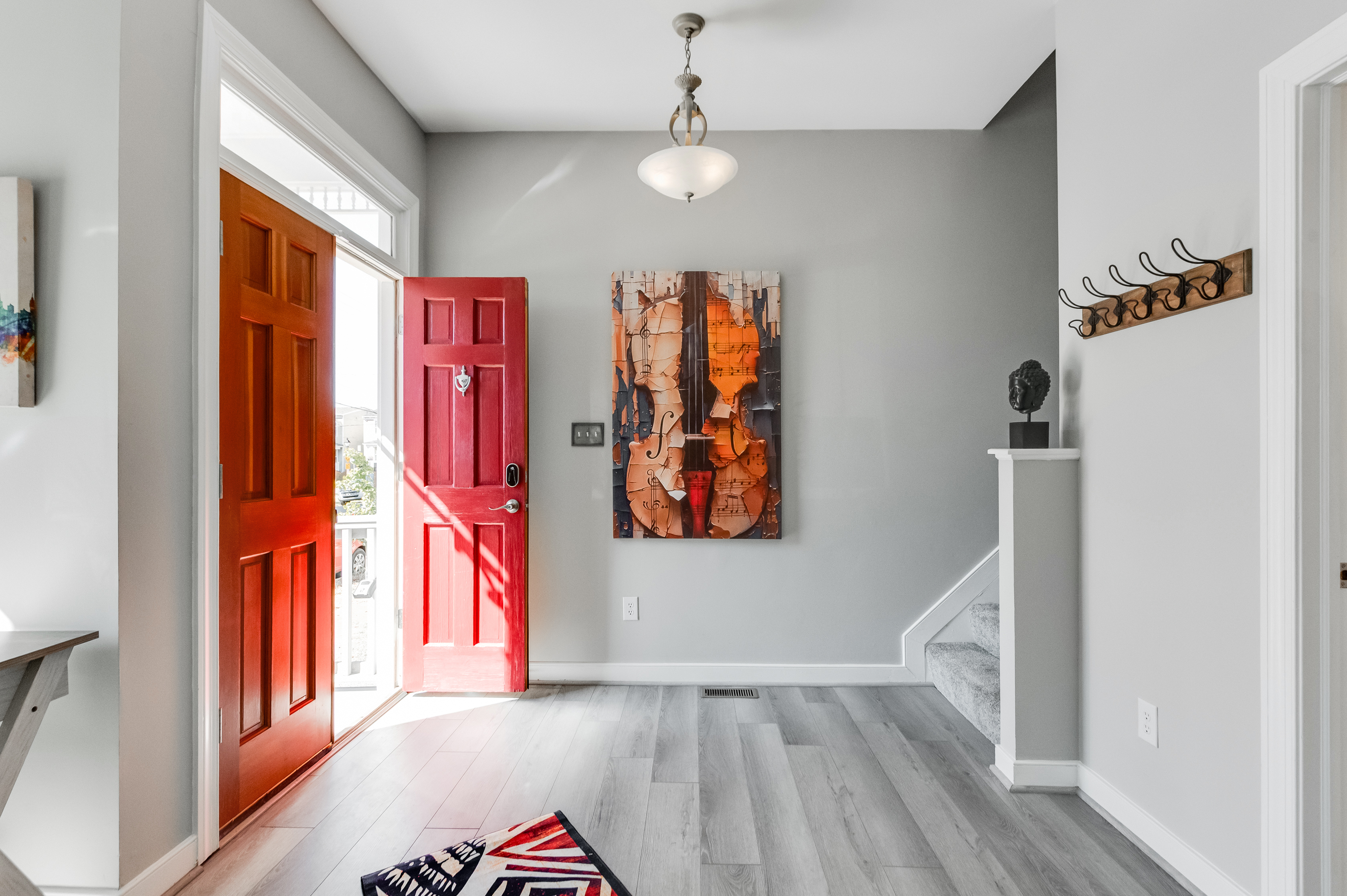 Entryway: Bright and inviting space with vibrant red doors and artistic accents awaits your arrival!