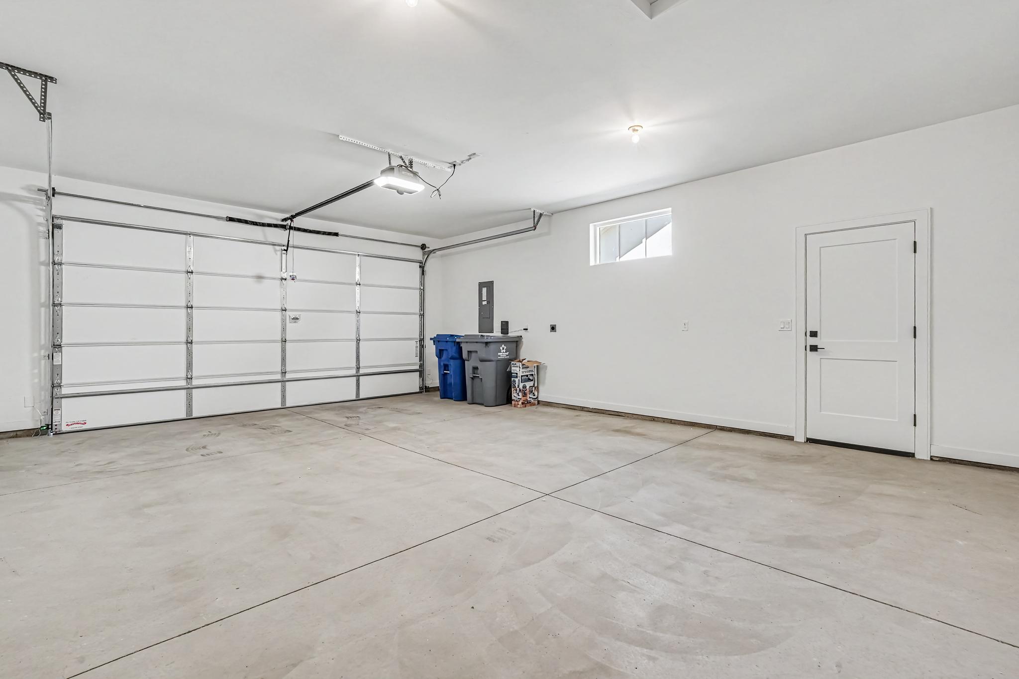 Spacious two-car garage with convenient access to the backyard through a dedicated side door.