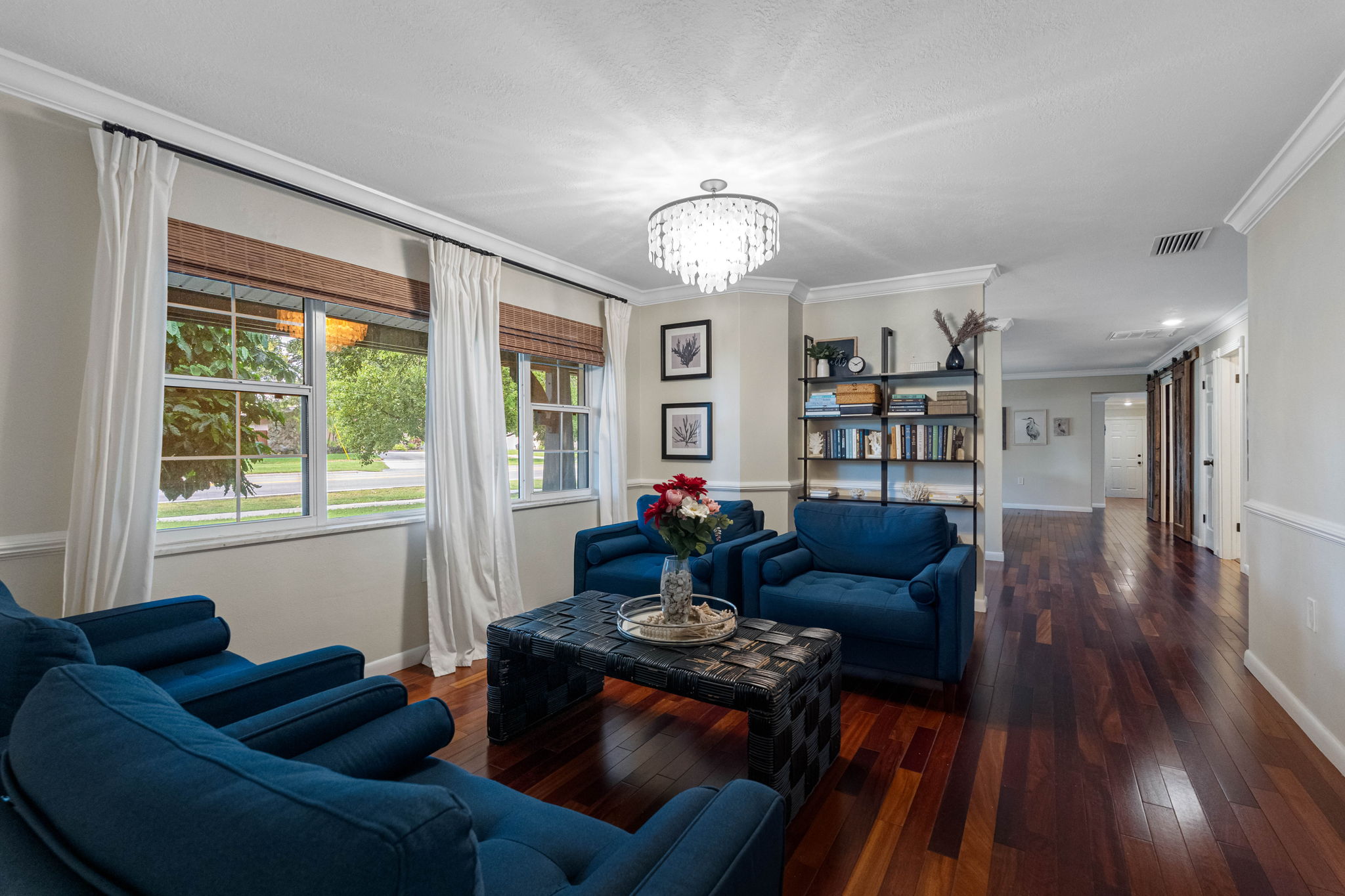 This cozy family room features rich hardwood floors, crown molding, and large windows that fill the space with natural light.