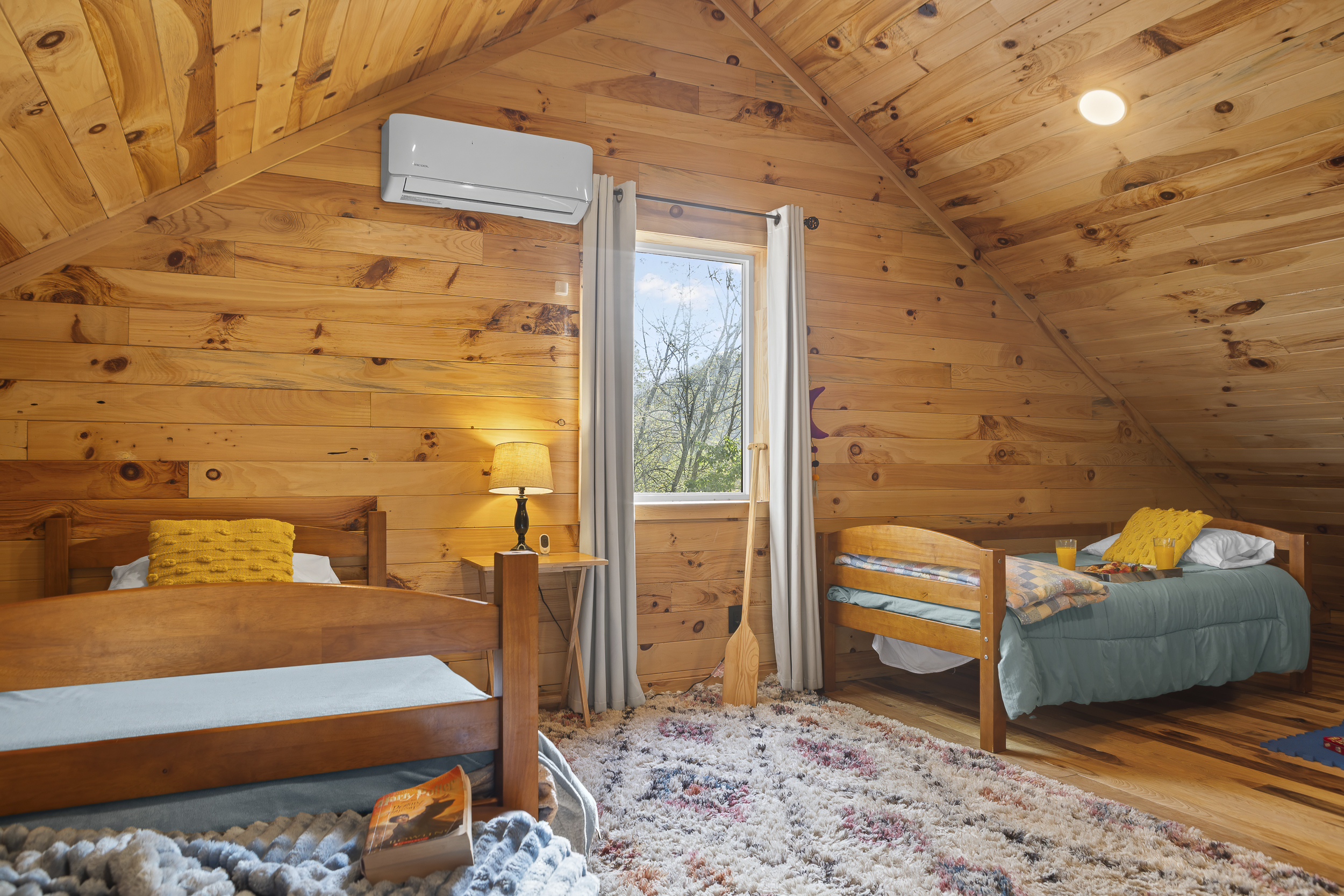 Loft Bedroom 4: Bright space featuring wood accents, playful decor, and a view for fun-filled mornings!