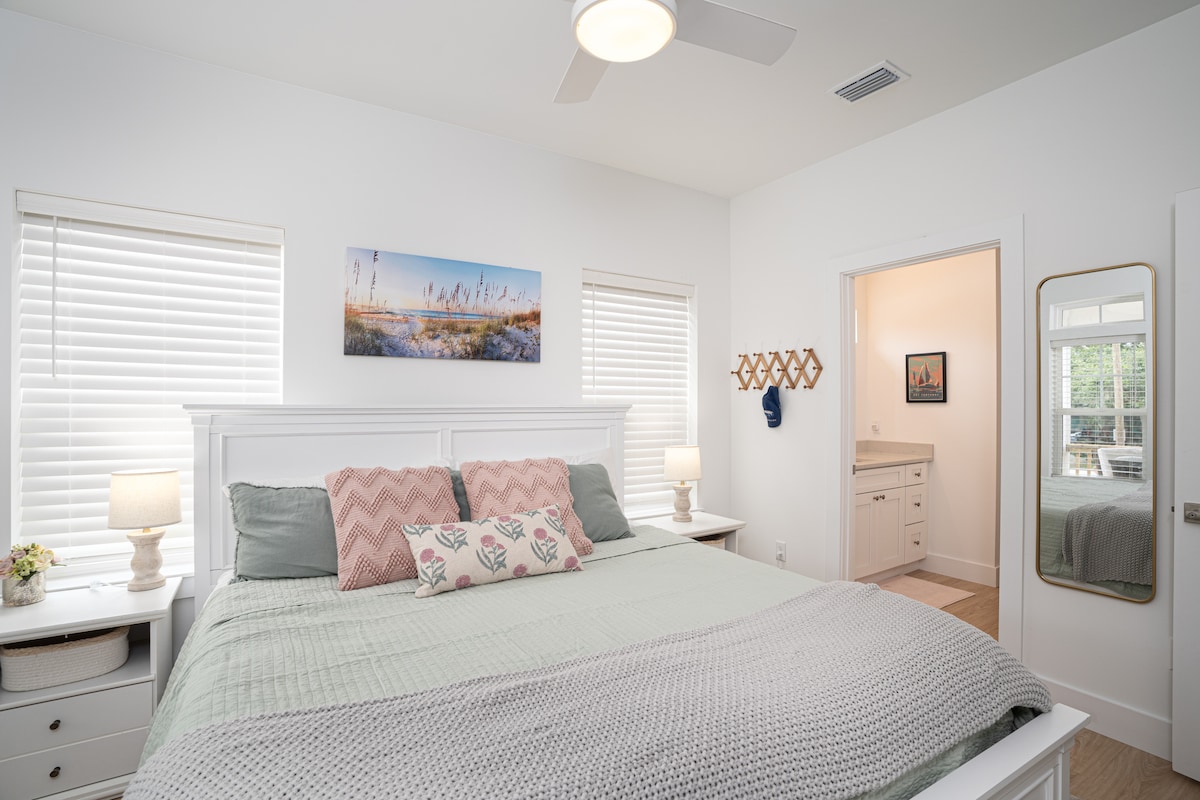 The main-floor king suite, with its own bathroom straight through the doorway. No stairs between you and the coffee pot in the morning, which is exactly why this room gets claimed by whoever booked the trip.