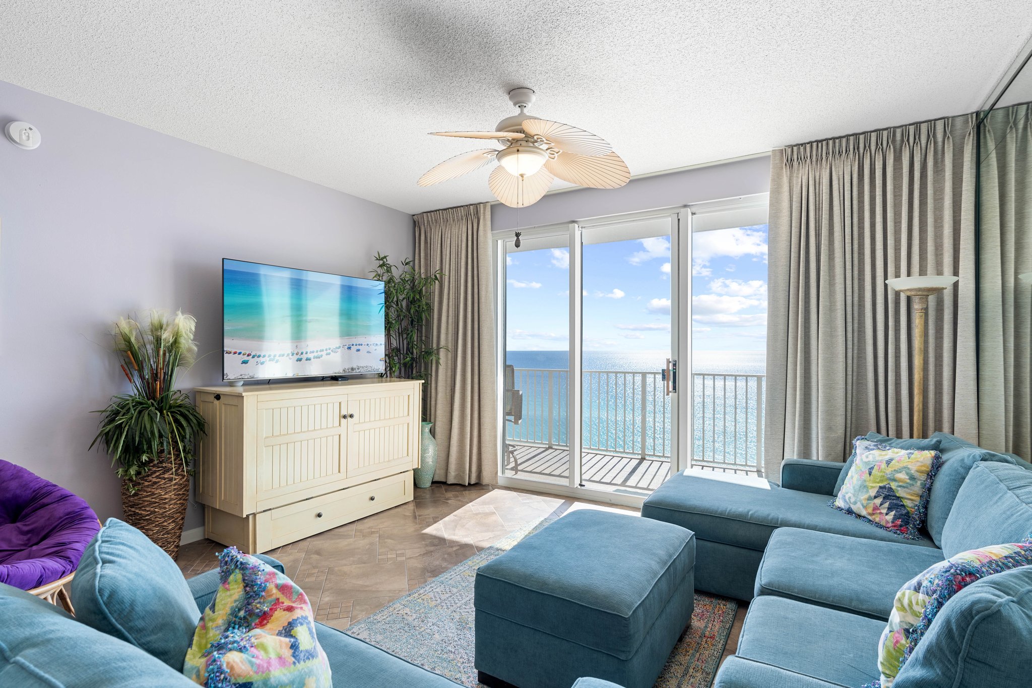 Inviting living room w/ plush sectional, TV & sliding doors opening to ocean views and fresh coastal breezes.