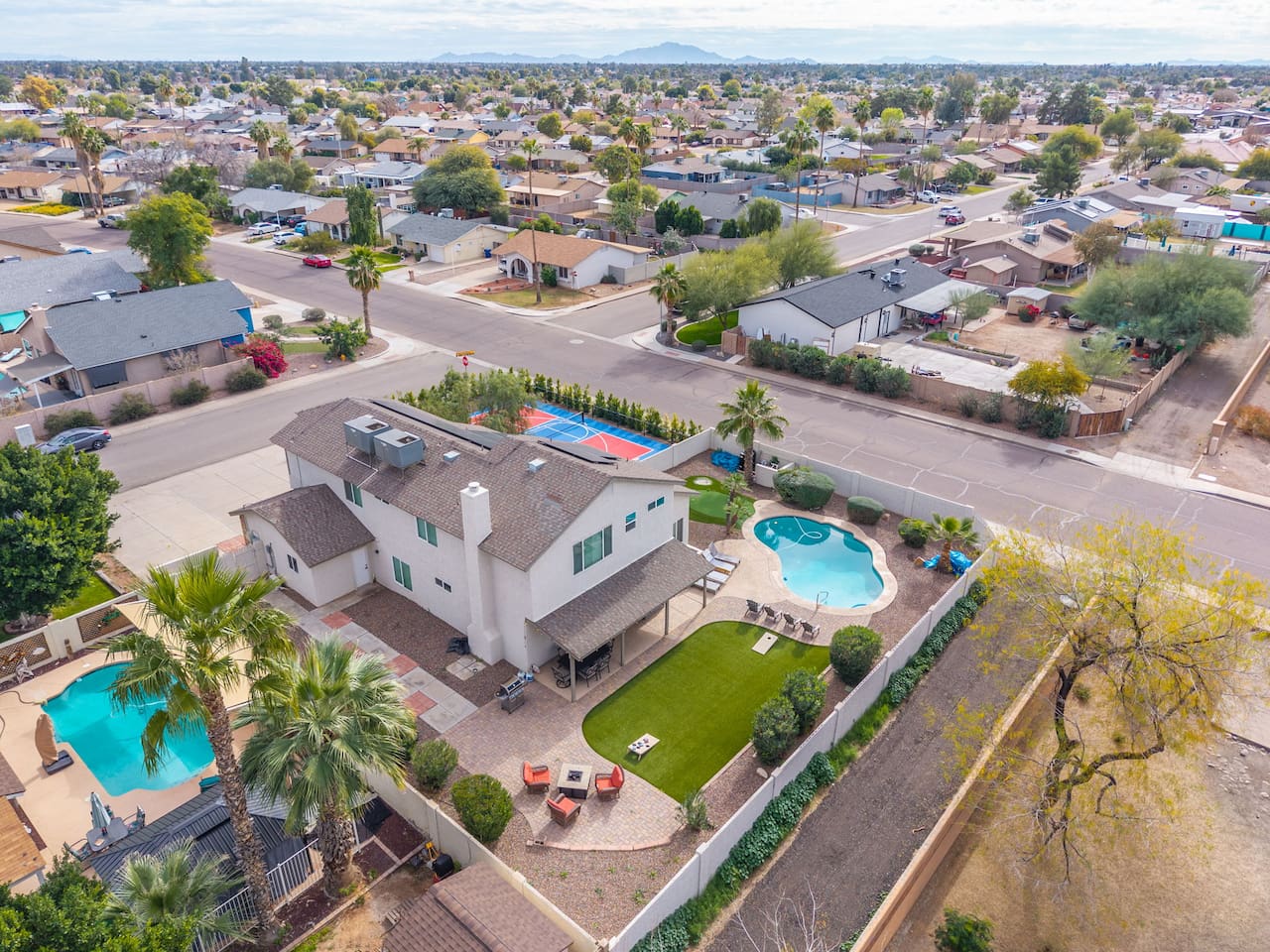 Modern home with resort pool, sports court, and sleek contemporary design in prime neighborhood location.