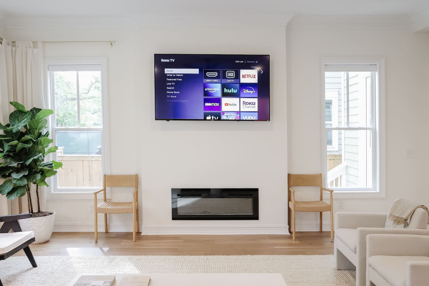 The light-filled living room features an oversized Floyd couch, a 70" smart TV and an open floor plan that flows seamlessly into the kitchen and dining areas. Great spot for hanging with a large group.