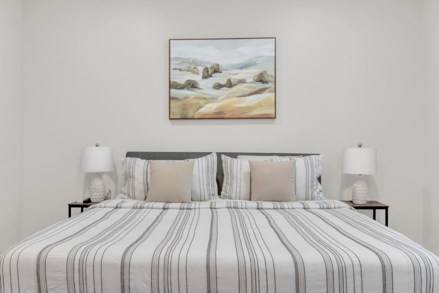 Master suite with neutral tones and stylish framed art.